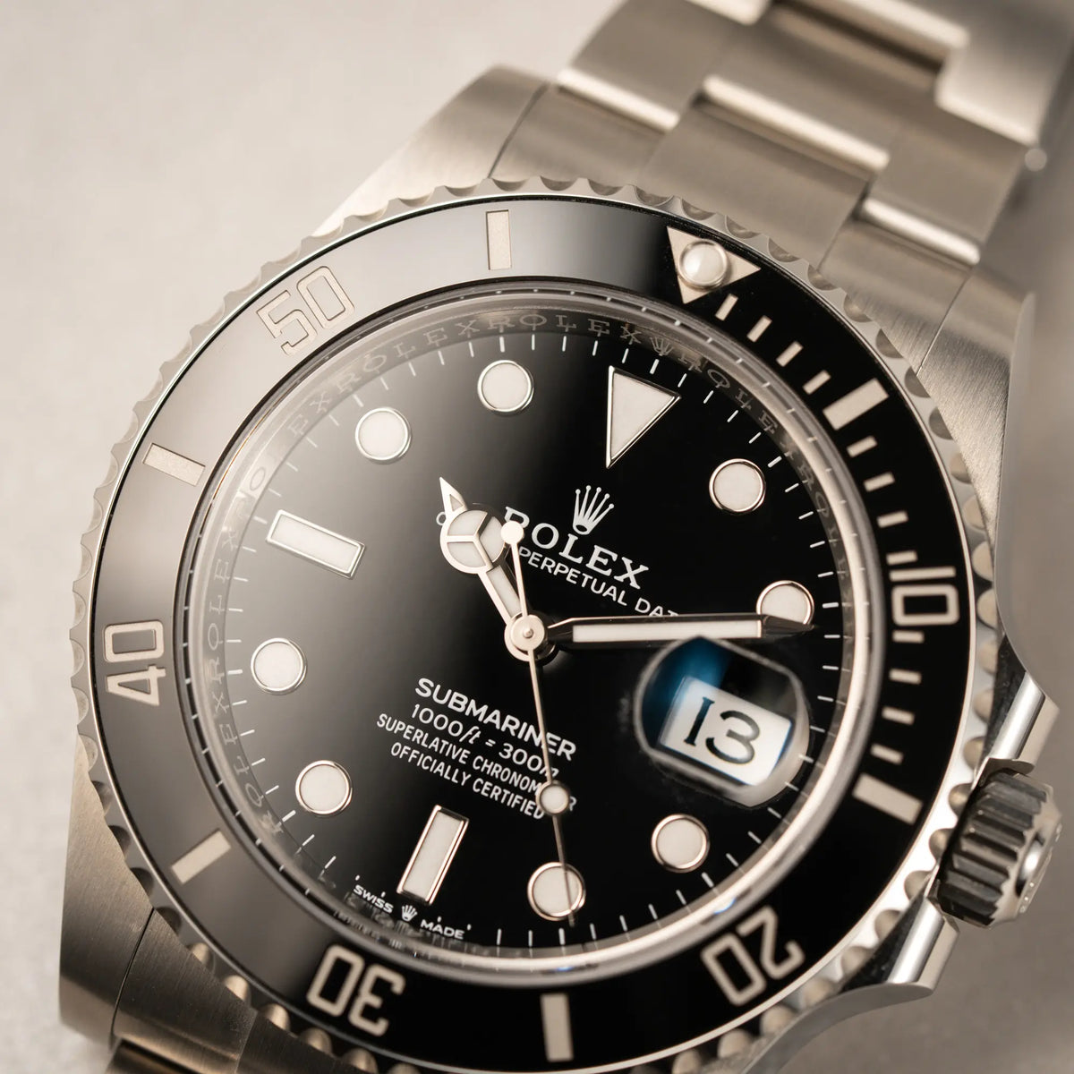 Makroaufnahme der Rolex Submariner Date in schwarz mit Keramik-Lünette  am Oyster-Stahlband aus 2023 mit dem 41mm-Oyster-Gehäuse mit Fokus auf dem Zeigersatz