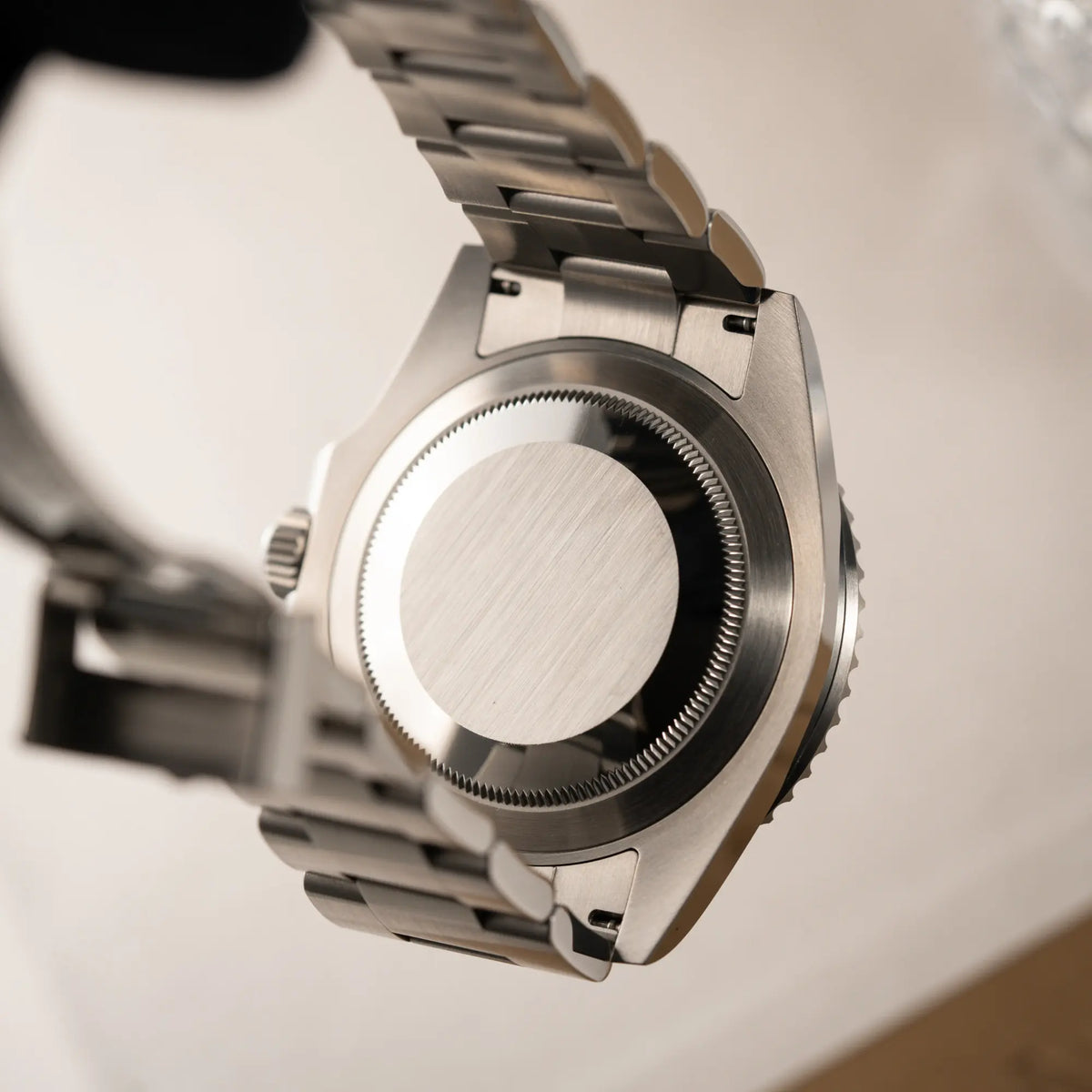 Produktfotografie der Produktfotografie der Rolex Submariner Date in schwarz mit Keramik-Lünette  am Oyster-Stahlband aus 2023 mit dem 41mm-Oyster-Gehäuse zeigt den verschraubten Gehäuseboden