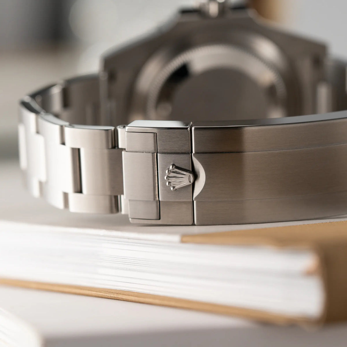 Detailaufnahme der Rolex-Krone auf der Oyster-Stahl-Faltschliesse der Rolex Submariner Date in schwarz mit Keramik-Lünette  am Oyster-Stahlband aus 2023 mit dem 41mm-Oyster-Gehäuse 