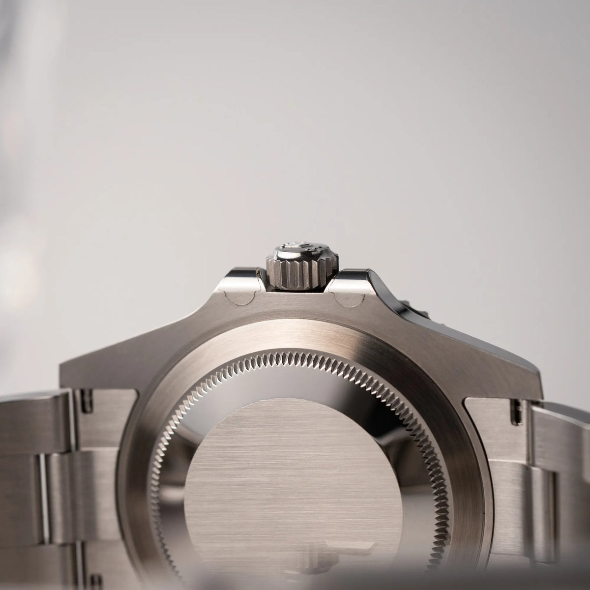 Produktfotografie zeigt die Unterseite der Rolex Submariner Date 126610LN am Oyster-Stahlband im Neuzustand aus 2024 mit Blick auf den Gehäuseboden und die noch verklebten Hörner des Kronenschutzes