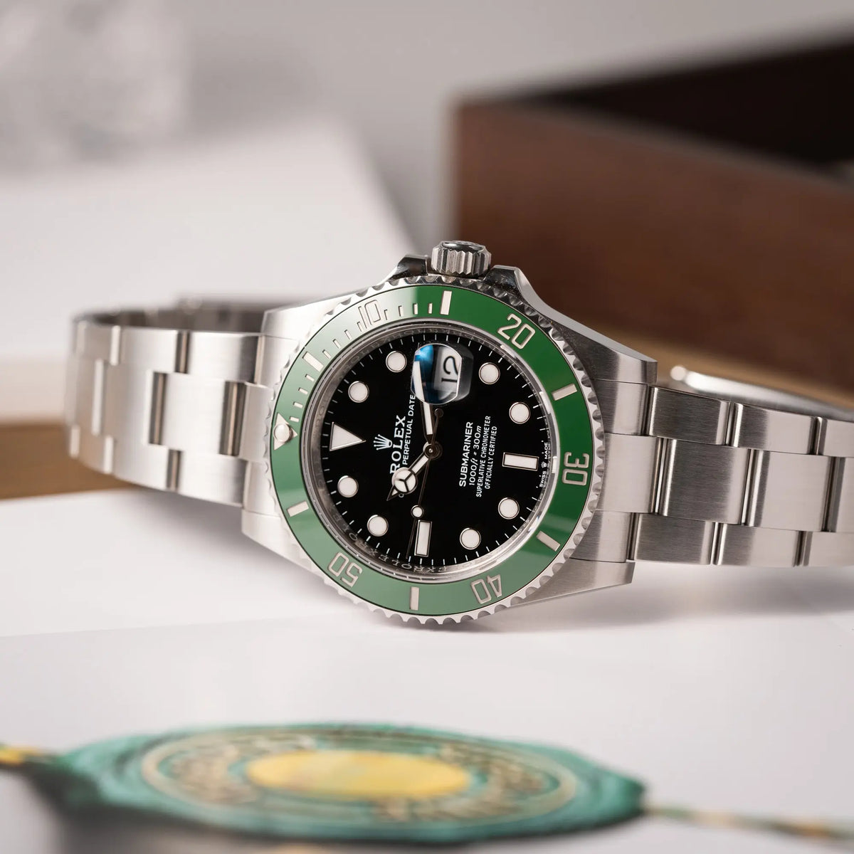 Produktfotografie der Rolex Submariner Date 126610LV, Nickname "Starbucks", mit schwarzem Zifferblatt und grüner Keramik-Lünette in der MK2-Ausführung am Oyster-Stahl-Band