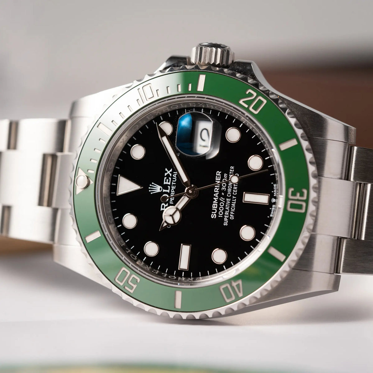 Detailaufnahme der seitlich auf dem Gehäuse liegenden Rolex Submariner Date 126610LV, Nickname "Starbucks", mit schwarzem Zifferblatt und grüner Keramik-Lünette in der MK2-Ausführung am Oyster-Stahl-Band