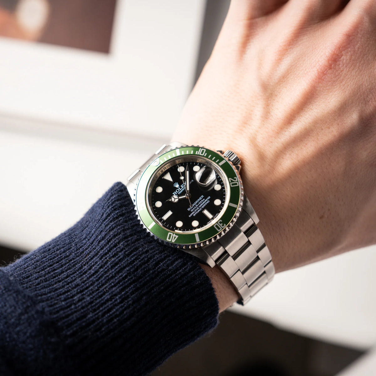 Mann trägt die Rolex Submariner Date 16610LV mit der grünen Aluminium-Lünetten-Einlage an seinem Handgelenk