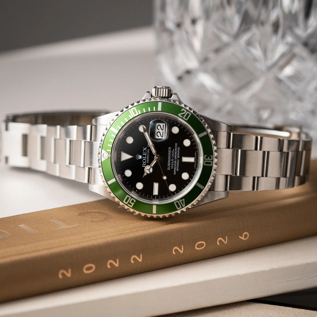 Produktfotografie als Titelbild für die Rolex Submariner Date 16610LV aus 2007 mit schwarzem Zifferblatt und der grünen "Kermit" Aluminium-Lünetten-Einlage