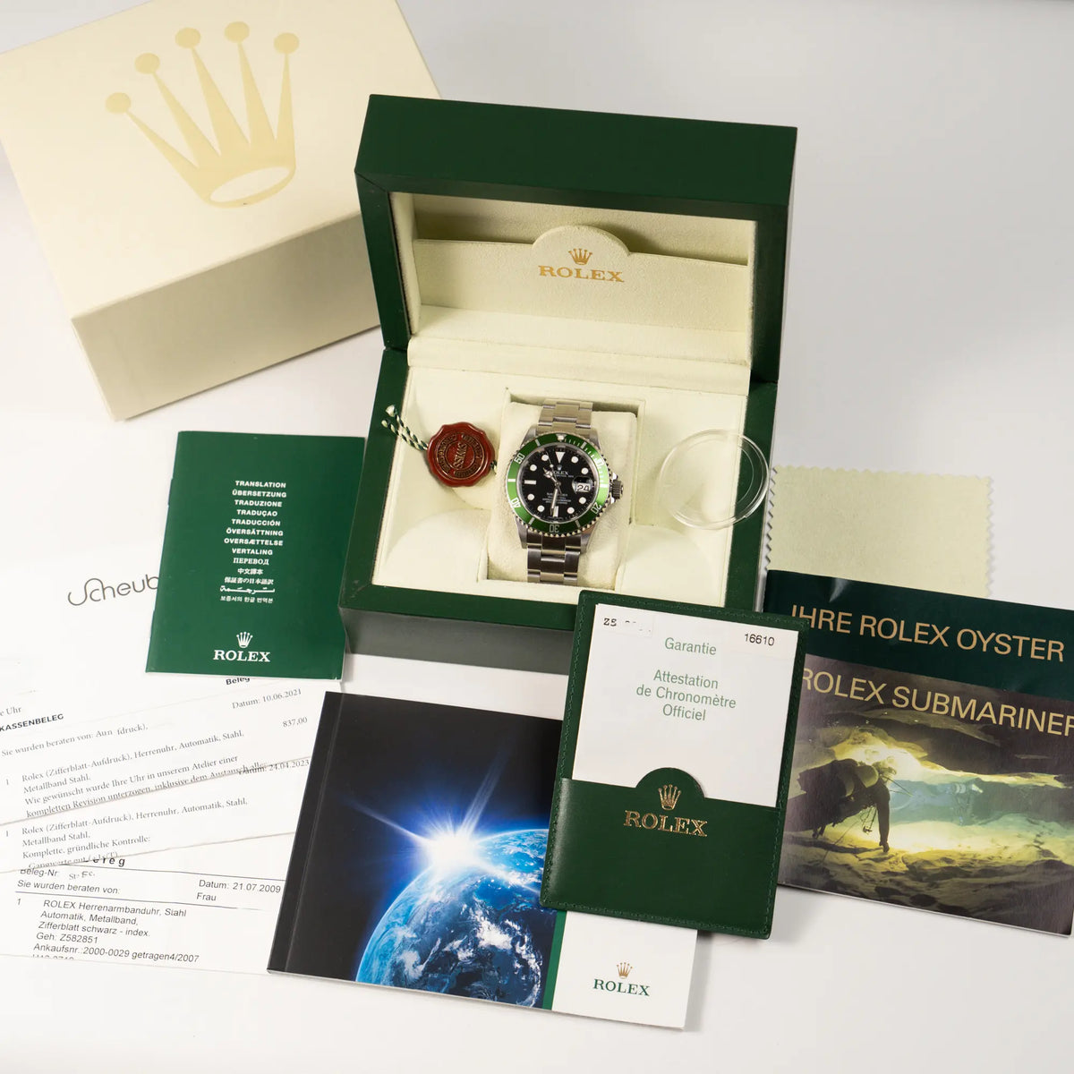 Rolex Submariner Date 16610LV aus 2007 mit schwarzem Zifferblatt und der grünen "Kermit" Aluminium-Lünetten-Einlage zusammen mit dem Lieferumfang, bestehend aus Box mit Umkarton, Booklets, original Papieren , Hangtag und Lünettenschutz, sowie die Rechnung zu dem Rolex-Service aus 2021