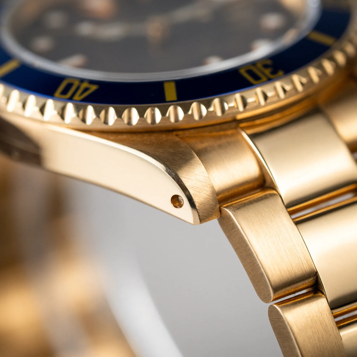 Produktfotografie der Rolex Submariner Date 16618 aus 18Karat Gelbgold mit blauer Lünetten-Einlage und einem sich von BLAU zu LILA verfärbtem Purple-Zifferblatt