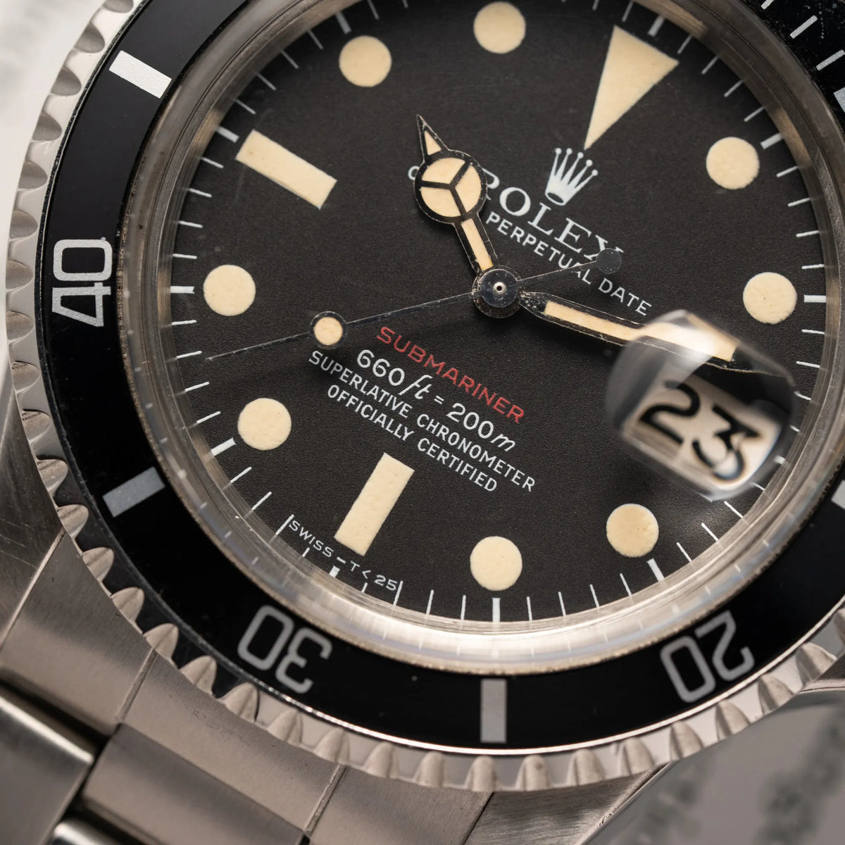 Detailaufnahme der Rolex Submariner Date 1680 mit dem Submariner Red Schriftzug auf dem Mark V Zifferblatt mit schöner gleichmäßiger Patina bei den Zeigern und Indizes zeigt den typischen Schriftzug bei 6 Uhr