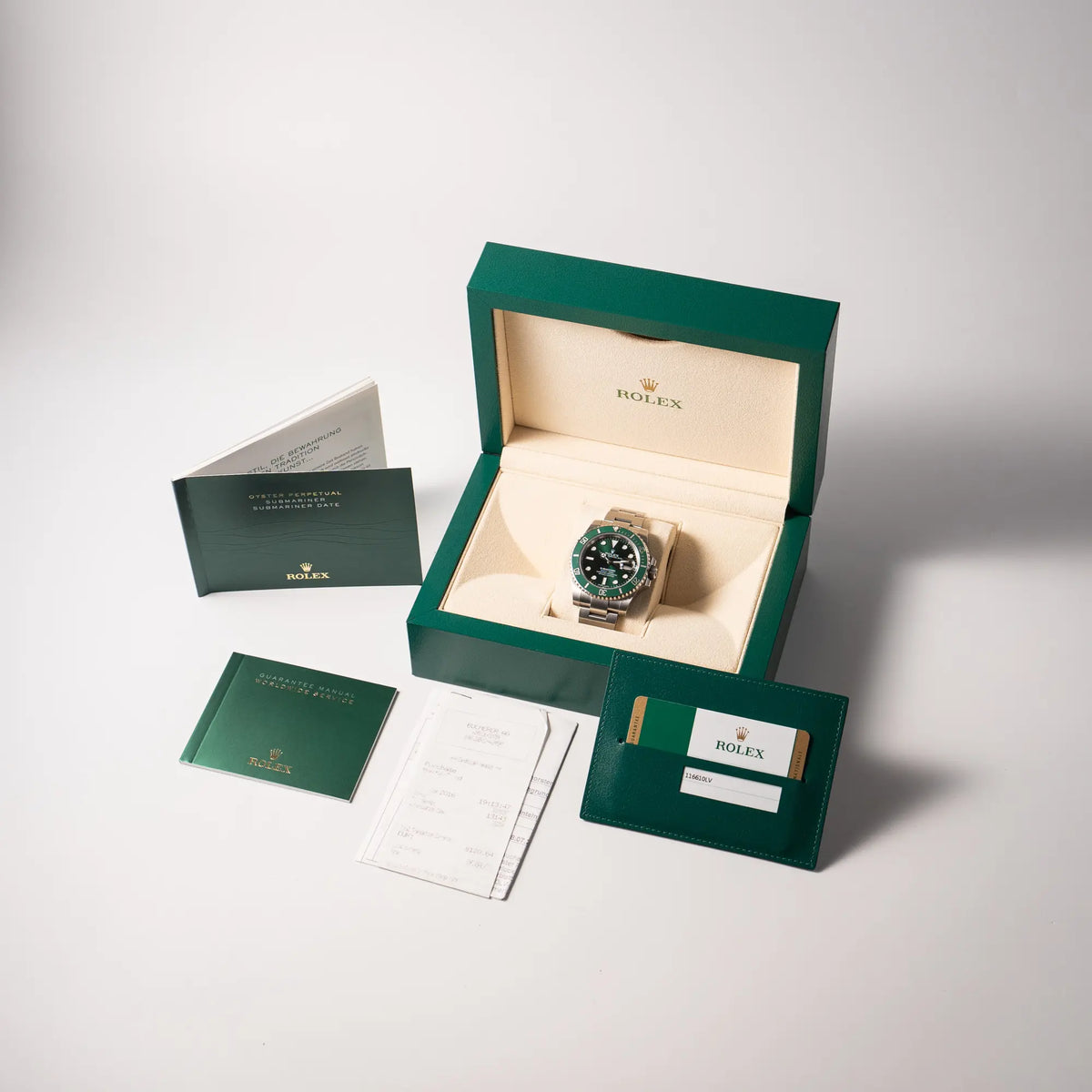Lieferumfang zu der Rolex Submariner Date 116610LV, Nickname "HULK", mit dem grünen Zifferblatt und der grünen Keramik-Lünette, an dem klassischen Oyster-Stahl-Armband, bestehend aus Box, Booklets, originaler Garantiekarte und Erstkaufbeleg