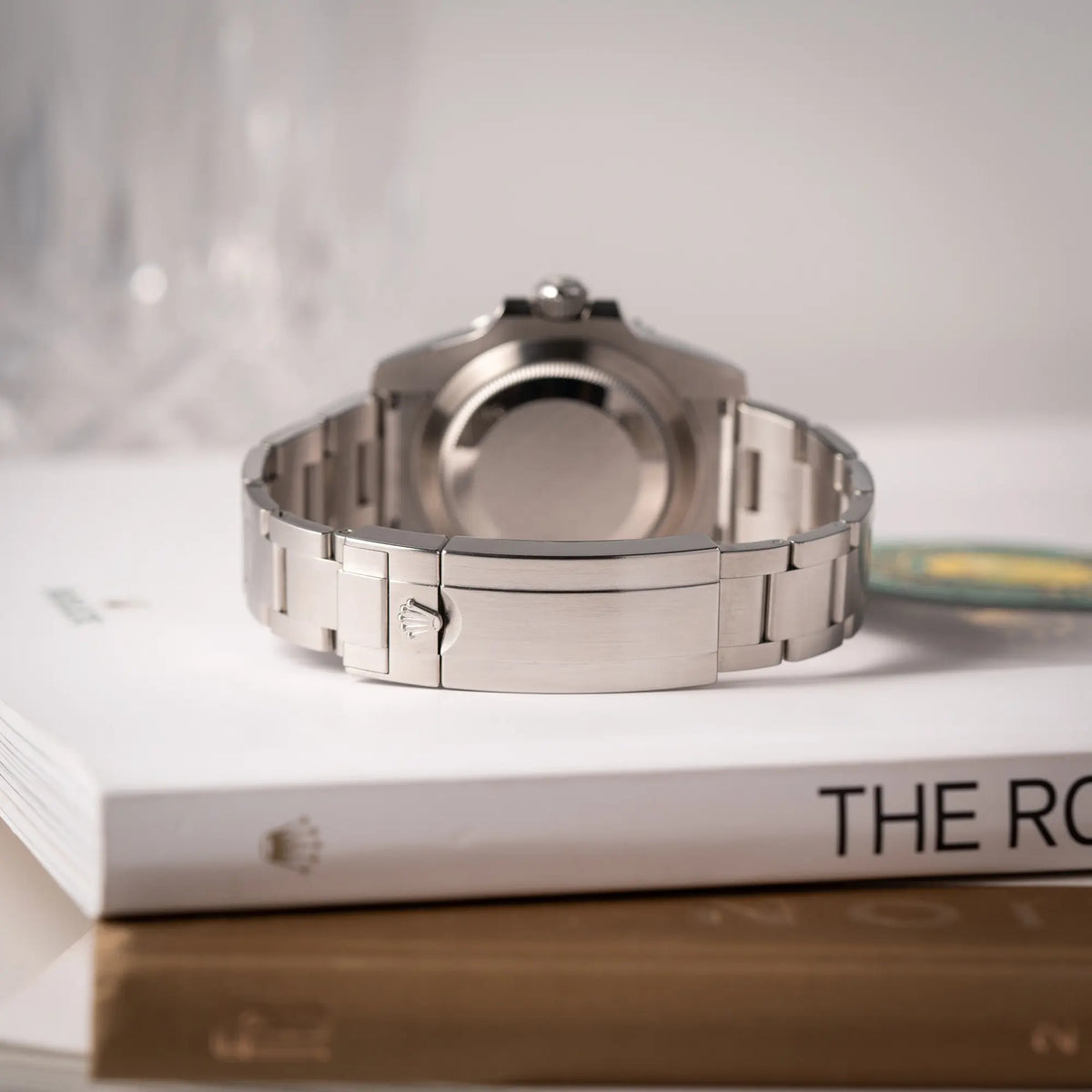 Produktfotografie zeigt die geschlossene Oyster-Faltschliesse der Rolex Submariner Date 116610LV, Nickname "HULK", mit dem grünen Zifferblatt und der grünen Keramik-Lünette, an dem klassischen Oyster-Stahl-Armband