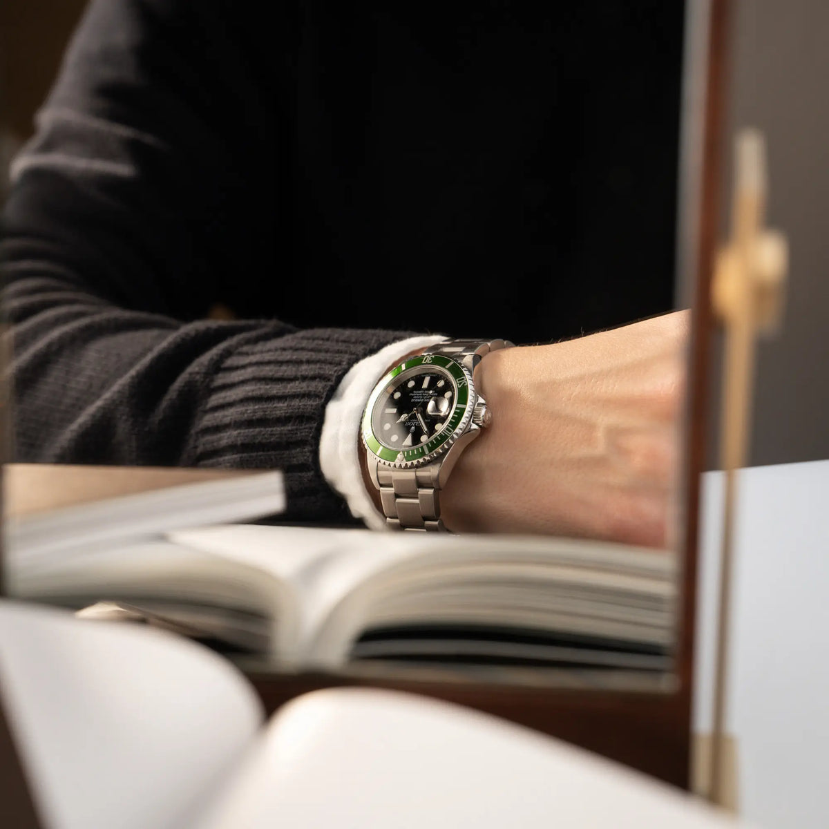 Mann trägt die Rolex Submariner Date 16610LV "Kermit" mit der schwarzem Zifferblatt und der grünen Aluminium-Lünette an seinem Handgelenk