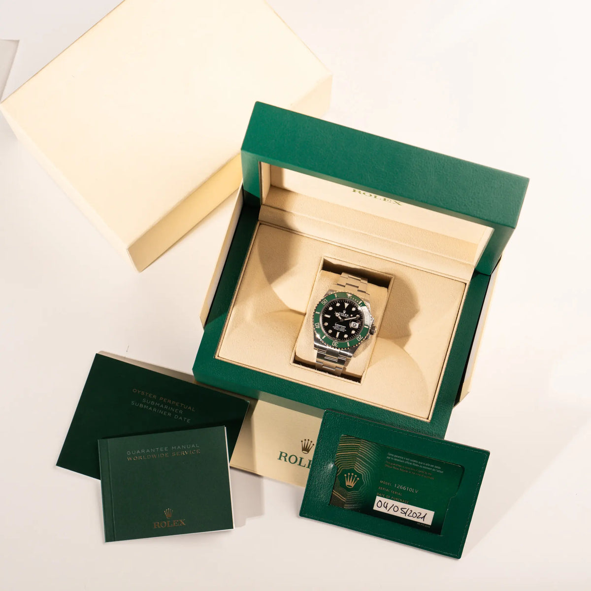 Lieferumfang zugehörig zu der Rolex Submariner Date Starbucks 126610LV mit schwarzem Zifferblatt und grüner Cerachrom-Lünette bestehend aus Box, Umkarton, Papieren und Booklets