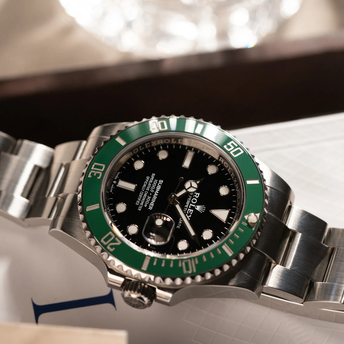 Produktfotografie der Rolex Submariner Date Starbucks 126610LV mit schwarzem Zifferblatt und grüner Cerachrom-Lünette zeigt die Bandanstöße