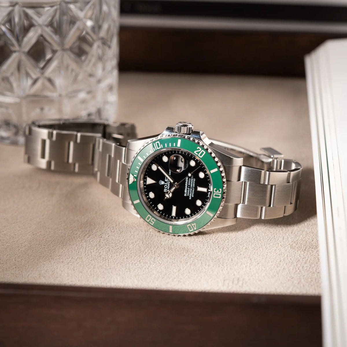 Rolex Submariner Date Starbucks 126610LV mit schwarzem Zifferblatt und grüner Cerachrom-Lünette liegt auf einem Juwelierstablet