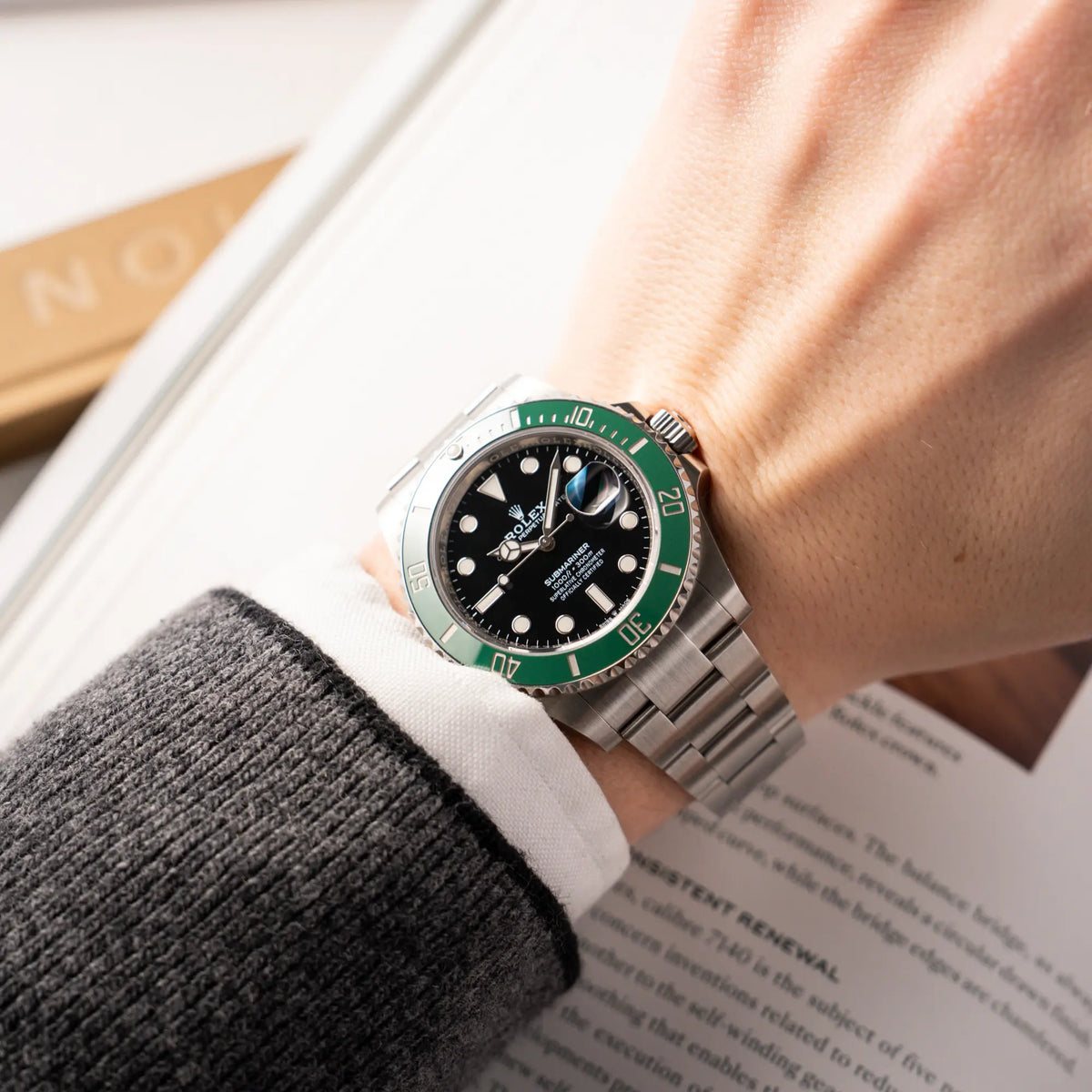 Mann trägt die Rolex Submariner Date Starbucks der Referenz 126610LV im 41mm Oyster-Case mit der typischen grünen Keramik-Lünette an seinem Handgelenk