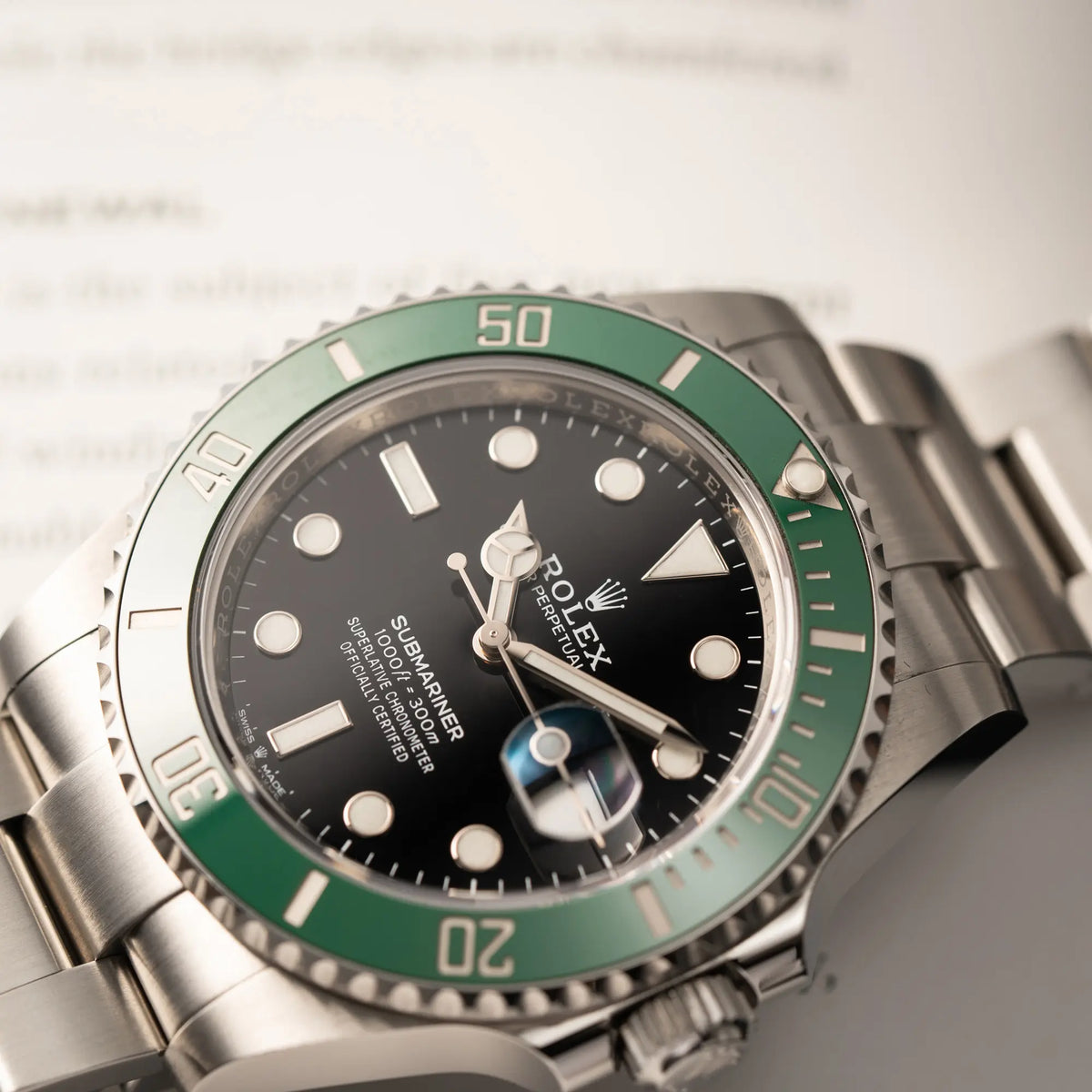 Produktfotografie mit Fokus auf dem Uhrenkopf der Rolex Submariner Date Starbucks der Referenz 126610LV im 41mm Oyster-Case mit der typischen grünen Keramik-Lünette