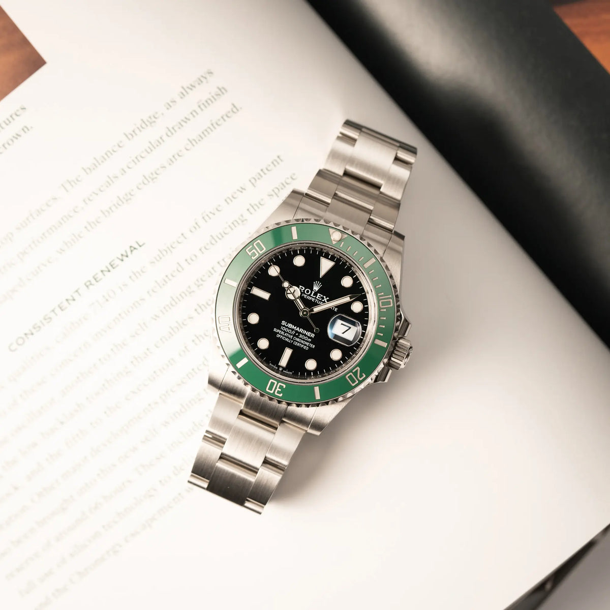 Produktfotografie zeigt die Rolex Submariner Date Starbucks der Referenz 126610LV im 41mm Oyster-Case mit der typischen grünen Keramik-Lünette aus der Vogelperspektive