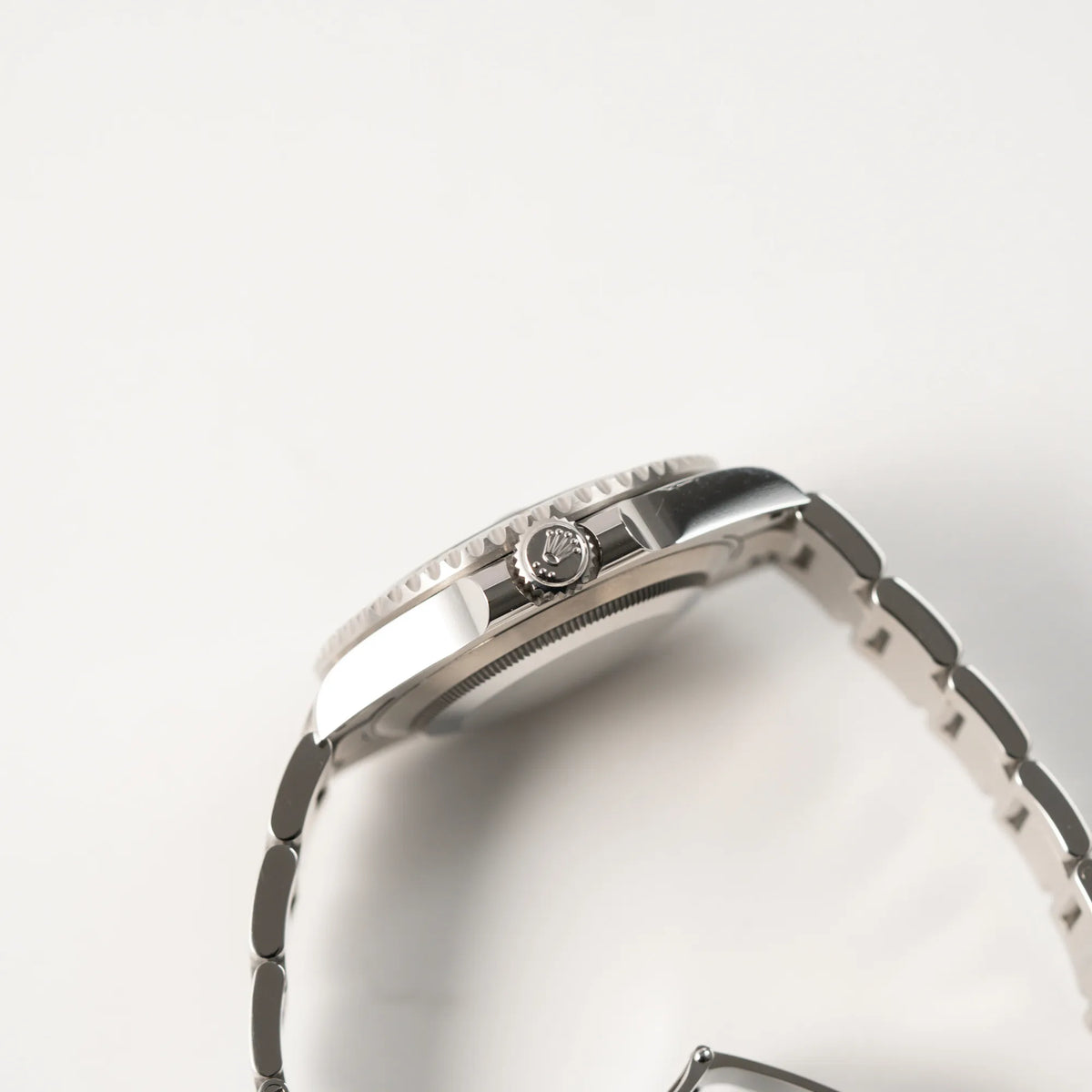 Seitliche Gehäuseflanke mit Blick auf die Aufzugskrone der Rolex Submariner Date Starbucks der Referenz 126610LV im 41mm Oyster-Case mit der typischen grünen Keramik-Lünette