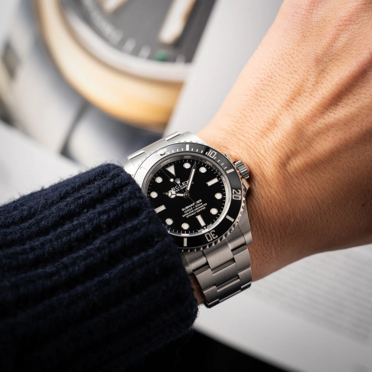 Mann trägt die Rolex Submariner No Date der Referenz 124060 mit schwarzem Zifferblatt und schwarzer Keramik-Lünette an einem Oytser-Stahlband im Neuzustand an seinem Handgelenk