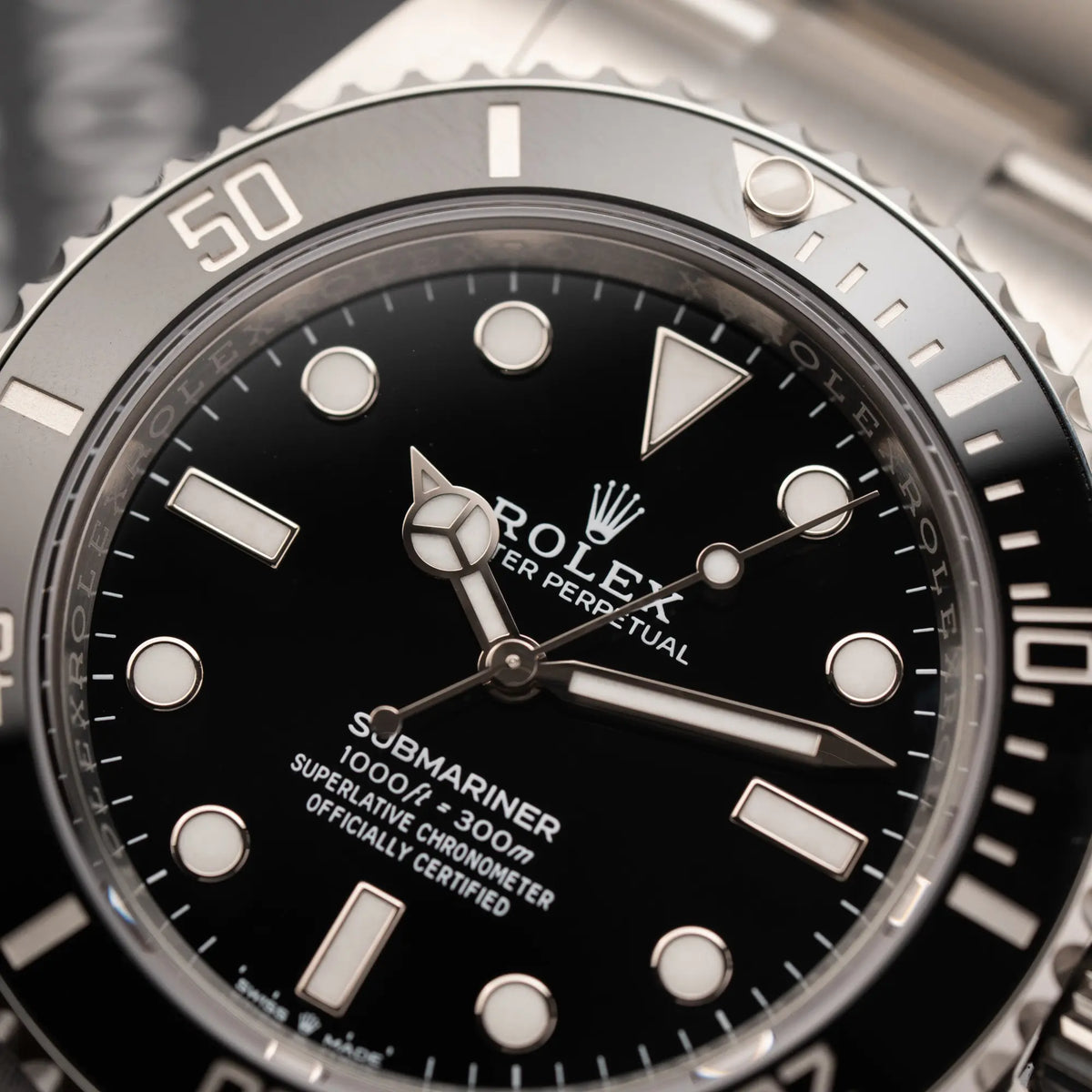 Detailaufnahme der Rolex Submariner No Date der Referenz 124060 mit schwarzem Zifferblatt und schwarzer Keramik-Lünette an einem Oytser-Stahlband im Neuzustand