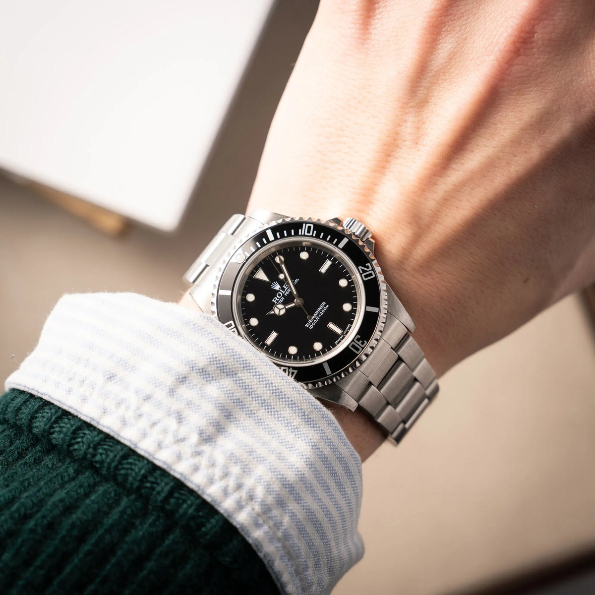 Wristshot mit der Rolex Submariner No Date 14060M mit schwarzem Zifferblatt und der klassischen schwarzen Aluminium-Lünette an einem Männerhandgelenk
