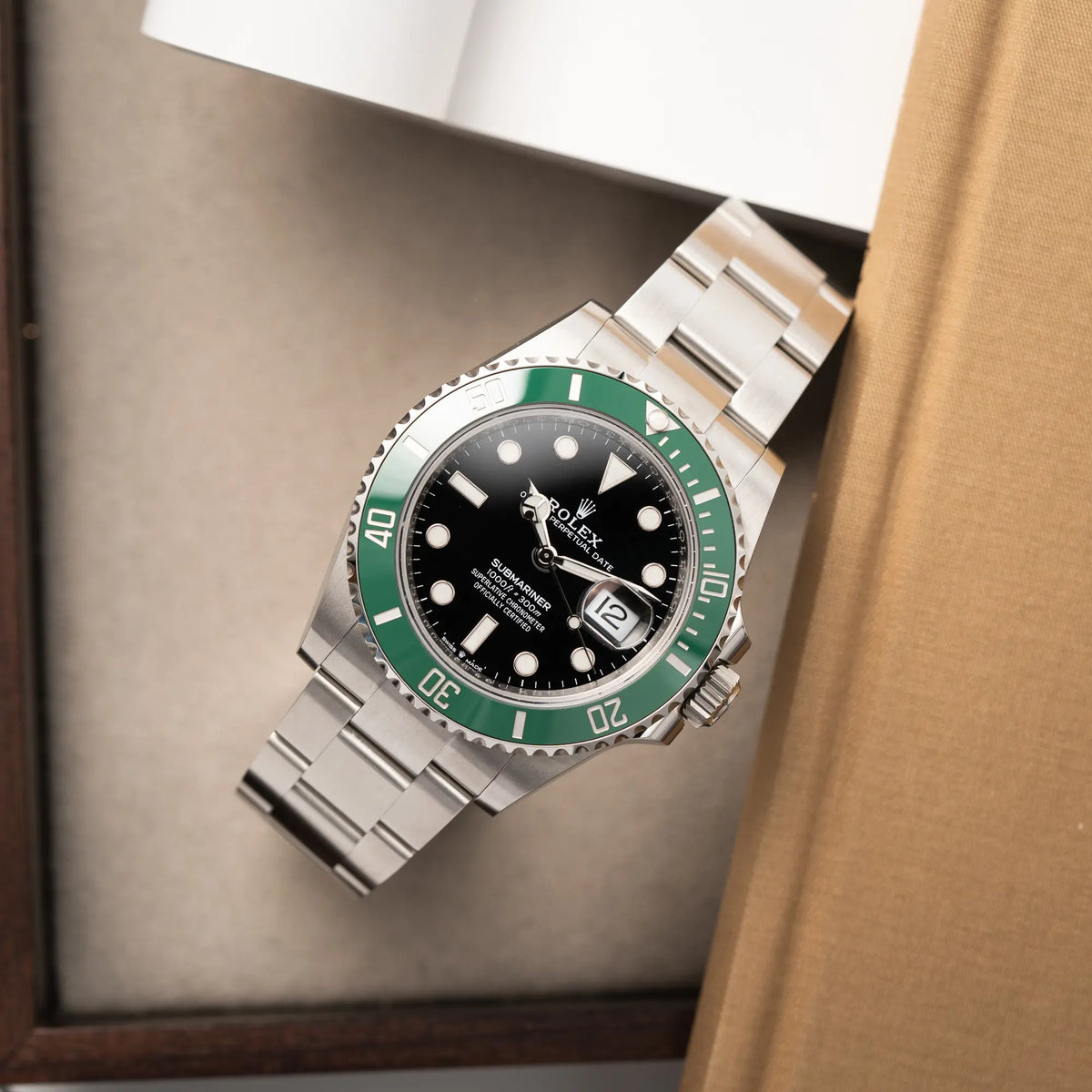 Produktfotografie der Rolex Submariner Date "Starbucks" der Referenz 126610LV mit der modelltypischen grünen Keramik-Lünette, die im Kontrast zu dem schwarzen Zifferblatt steht, im Neuzustand