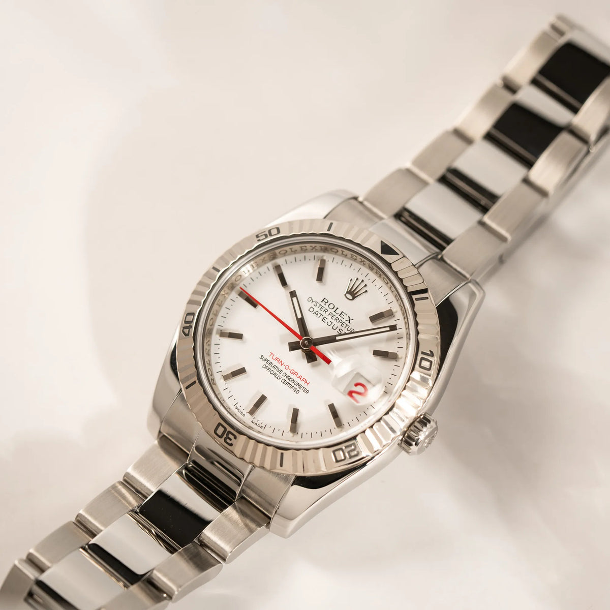 Rolex  Datejust Turn-O-Graph 116264 in 36 mm mit dem weißen Zifferblatt und dem roten Sekundenzeiger  mit spiegelndem Licht in der geriffelten Lünette