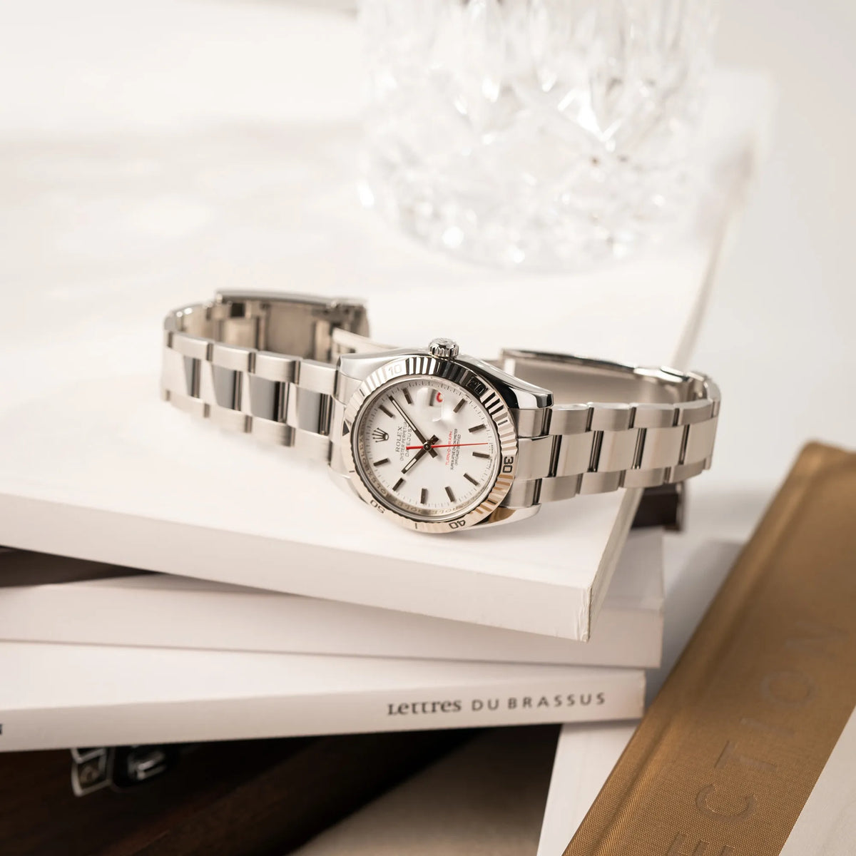 Produktfotografie der liegenden Rolex  Datejust Turn-O-Graph 116264 in 36 mm mit dem weißen Zifferblatt und dem roten Sekundenzeiger 