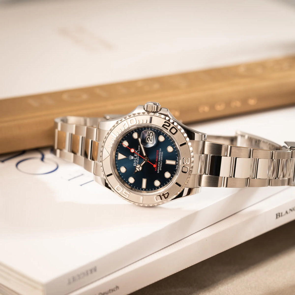Produktfotografie der seitlich auf dem Uhrengehäuse liegenden Rolex Yacht-Master 40 mit blauem Zifferblatt der Referenz 126622 aus 2022