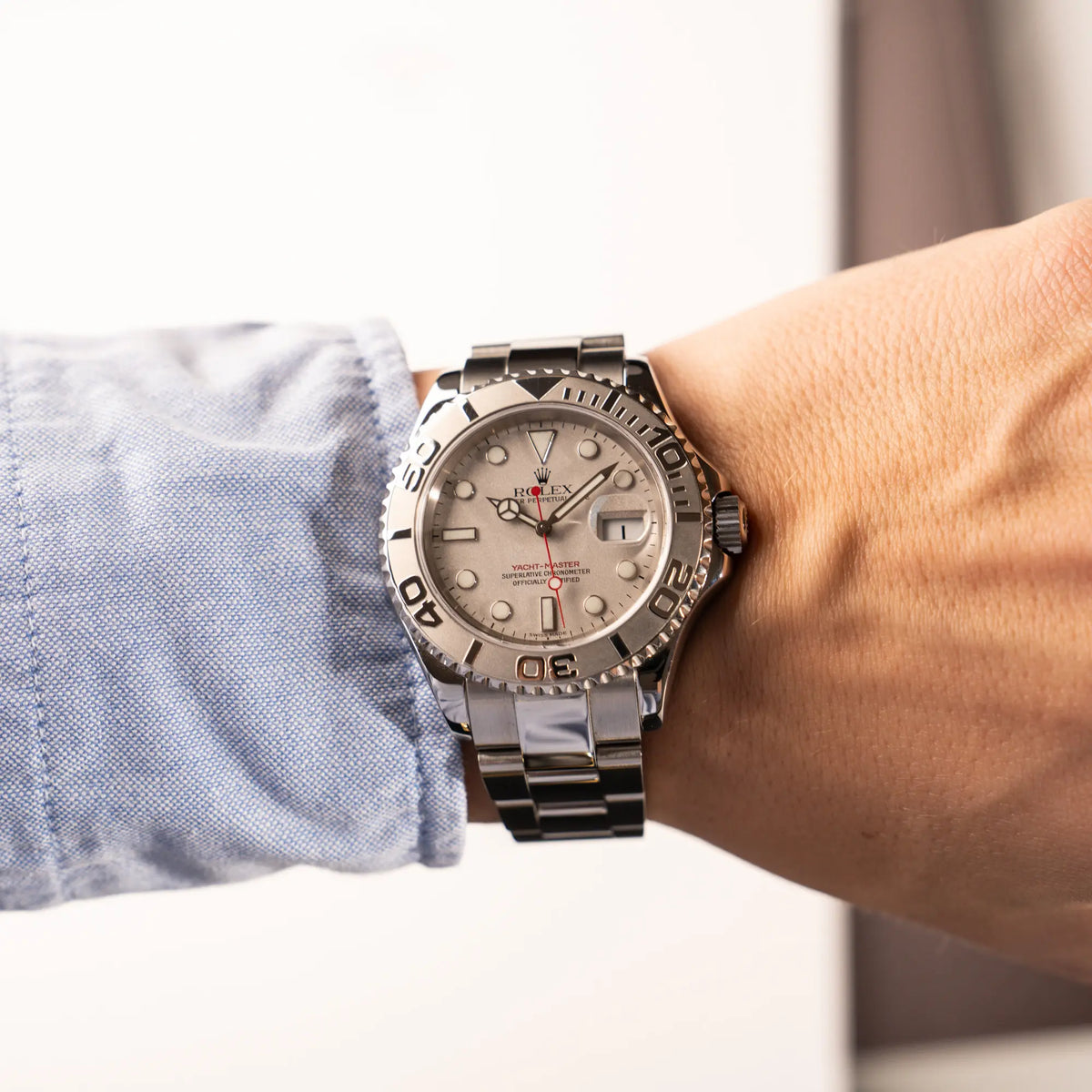 Mann trägt die Rolex Yachtmaster 40 Platinum mit der Referenz 16622 mit Platin-Lünette und dem typischen roten Sekundenzeiger für einen Wristshot an seinem Handgelenk