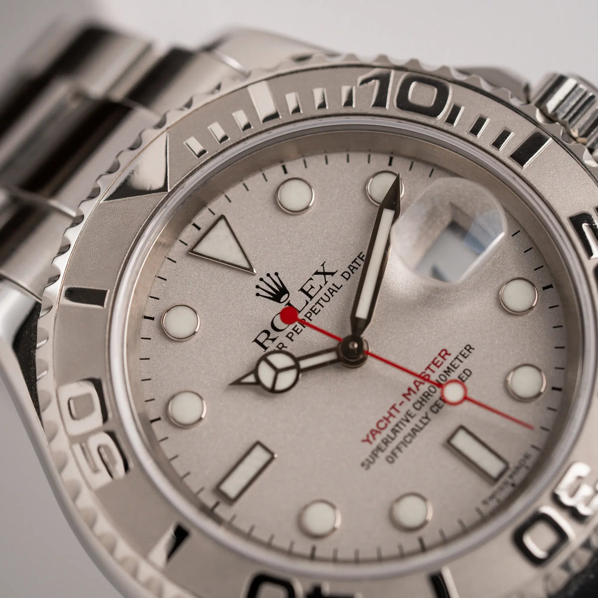 Makroaufnahme der PLatin-Lünette bei 12 Uhr von der Rolex Yachtmaster 40 Platinum mit der Referenz 16622 mit dem typischen roten Sekundenzeiger