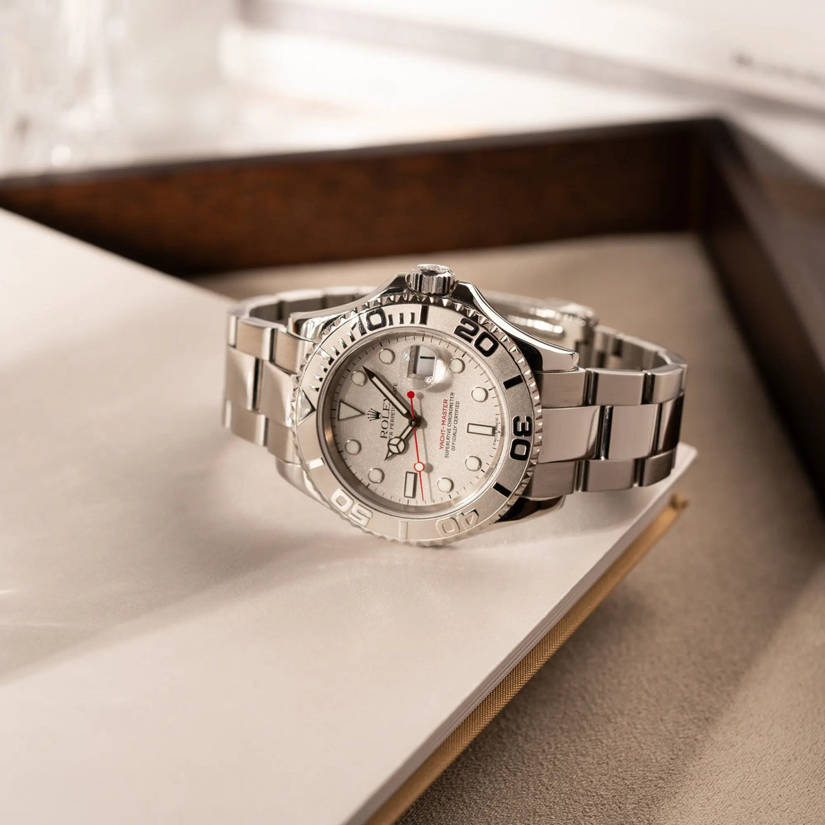 Rolex Yachtmaster 40 Platinum mit der Referenz 16622 mit Platin-Lünette und dem typischen roten Sekundenzeiger liegt auf Juwelierstablet