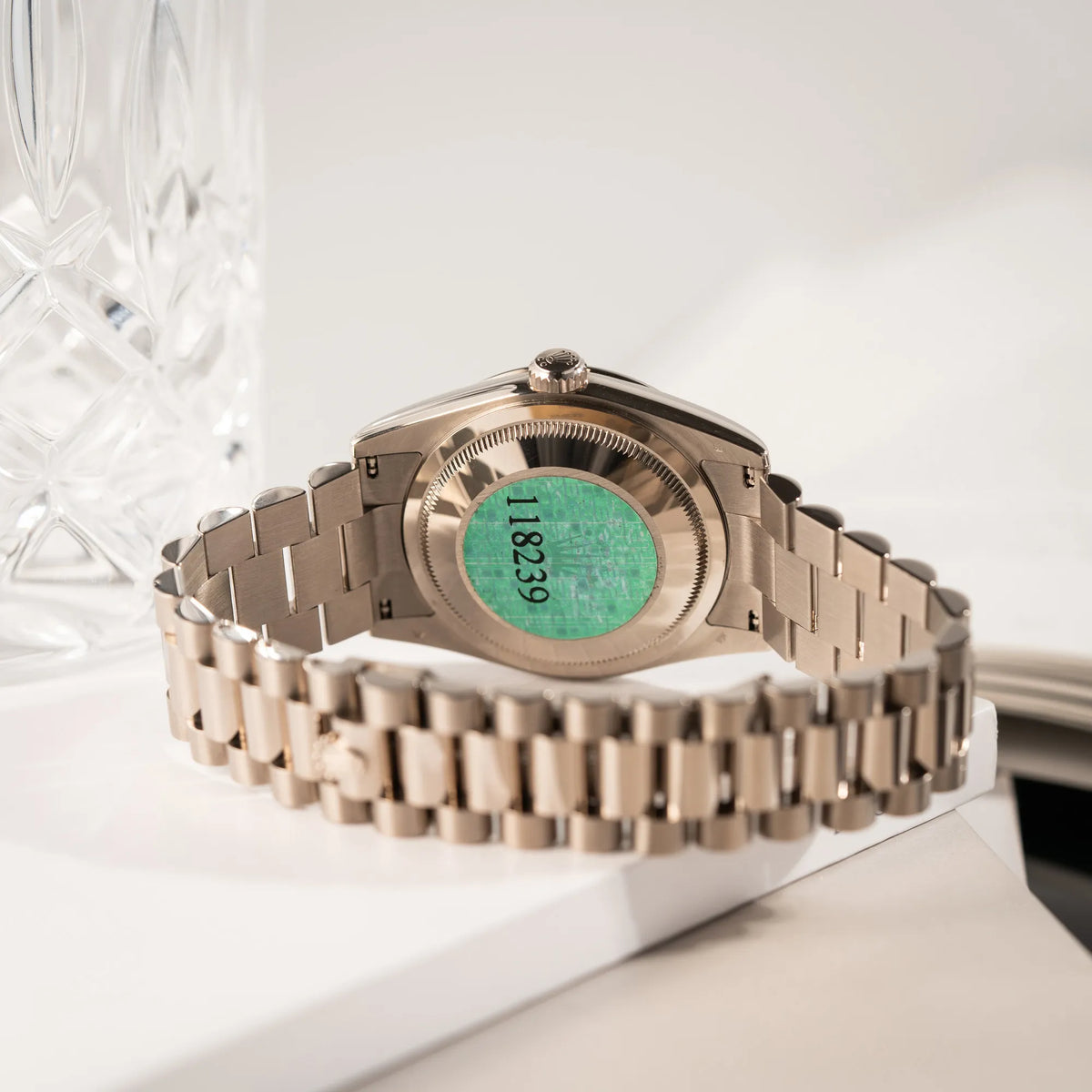 Produktfotografie zeigt den Gehäuseboden mit Sticker der Rolex Day-Date 36 der Referenz 118239 in 750er Weißgold gefertigt mit dem klassischen President-Armband