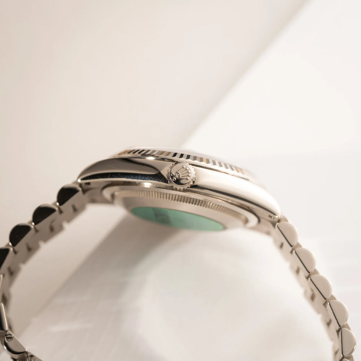Produktfotografie der seitlichen Gehäuseflanke mit Aufzugskrone der Rolex Day-Date 36 der Referenz 118239 in 750er Weißgold gefertigt mit dem klassischen President-Armband