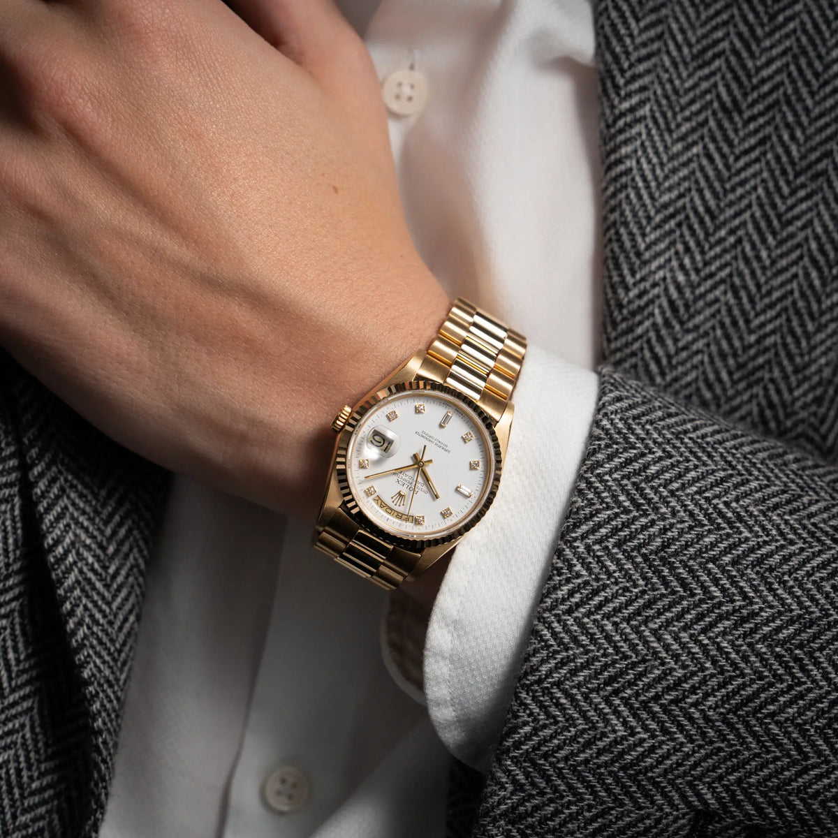 Mann im Sakko trägt die Rolex Day-Date 36 der Referenz 18238 in Gelbgold mit weißem Diamant-Zifferblatt