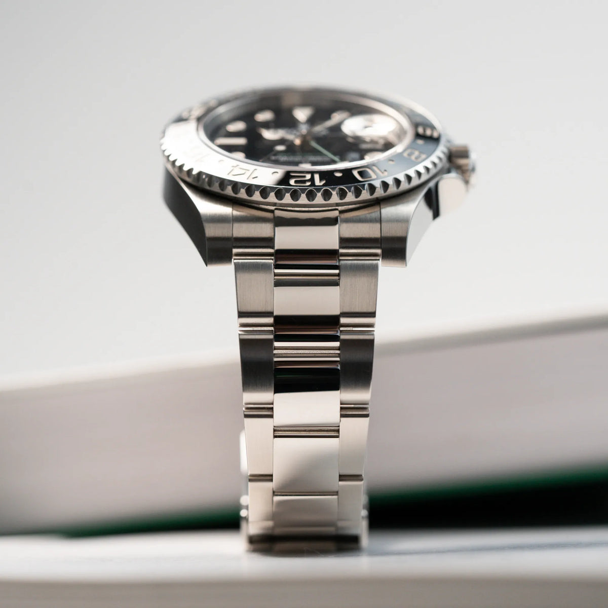 Produktfotografie der Rolex GMT Master 2 in Schwarz mit der Keramik-Lünette mi Fokus auf dem Oyster-Stahlband in einem fast neuen Zustand