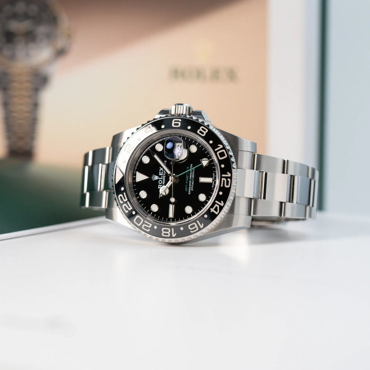 Produktfoto einer liegenden Rolex GMT Master 2 in Schwarz mit der Keramik-Lünette 