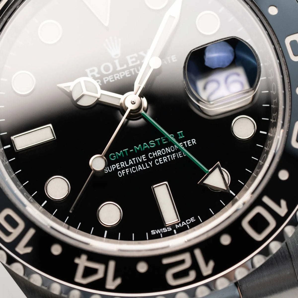 Detailaufnahme des schwarzen Zifferblatts der Rolex GMT Master 2 mit dem grünen GMT-Zeiger