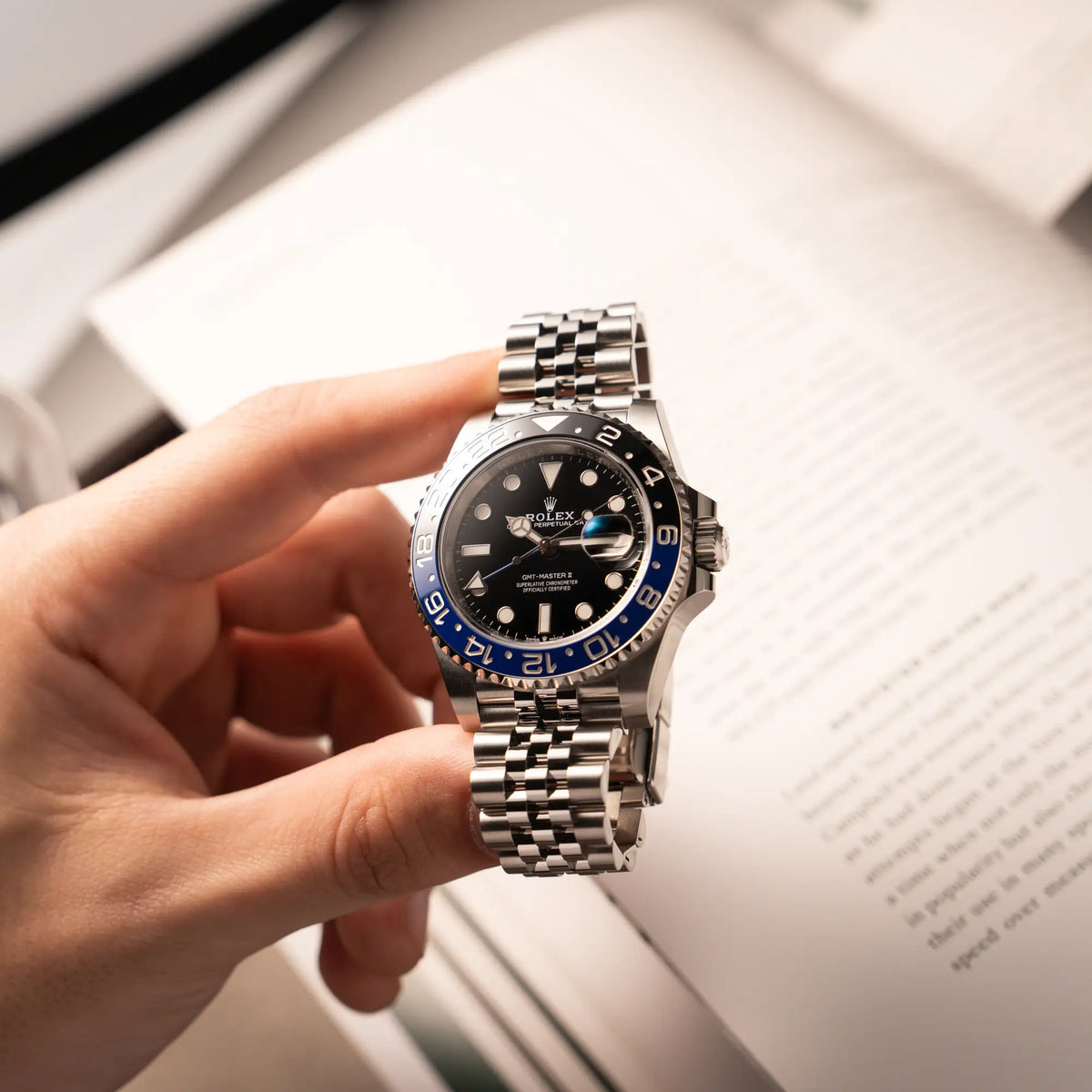 Mann hält die Rolex GMT-Master II  Batgirl der Referenz 126710BLNR mit blau schwarzer Lünette am Jubilee-Armband in seiner Hand und präsentiert die Uhr in die Kamera