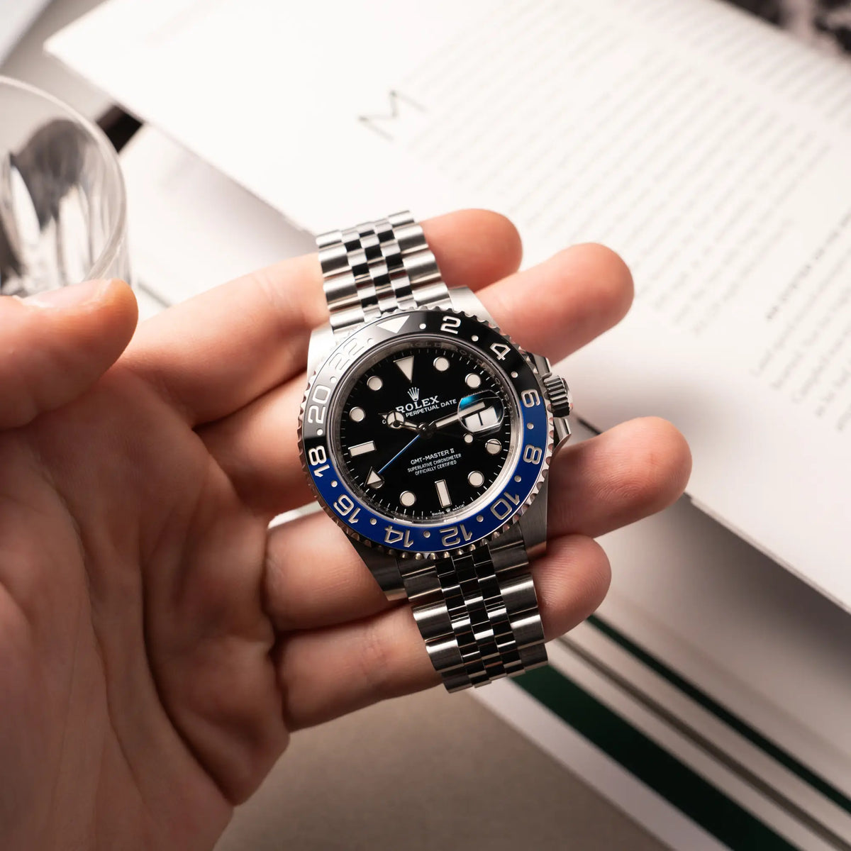 Mann hält die Rolex GMT-Master II  Batgirl der Referenz 126710BLNR mit blau schwarzer Lünette am Jubilee-Armband in seiner Hand
