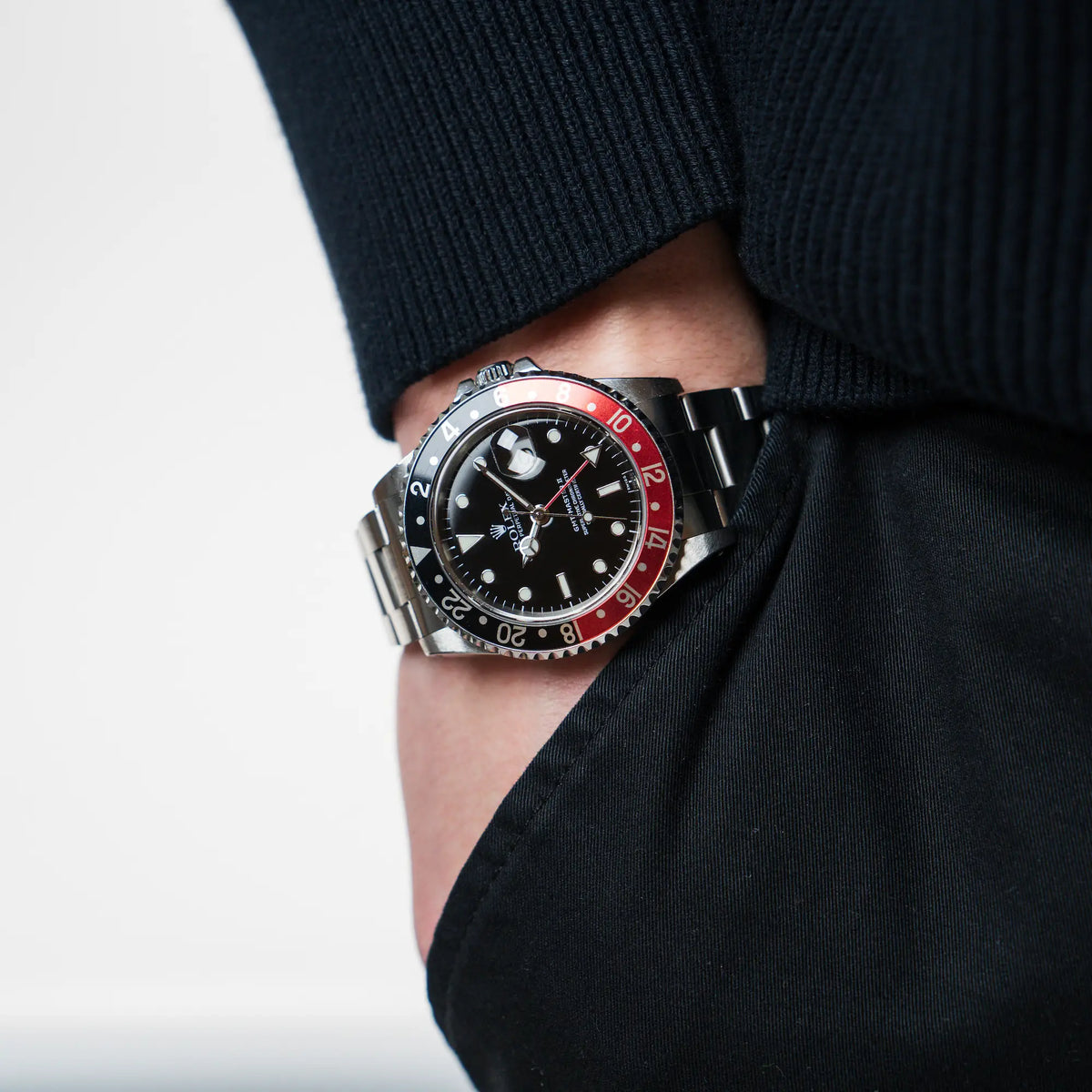 Mann trägt die Rolex GMT Master 2 (Referenz 16710) mit der Coke-Lünette an seinem Handgelenk, während seine Hand in der Hosentasche steckt