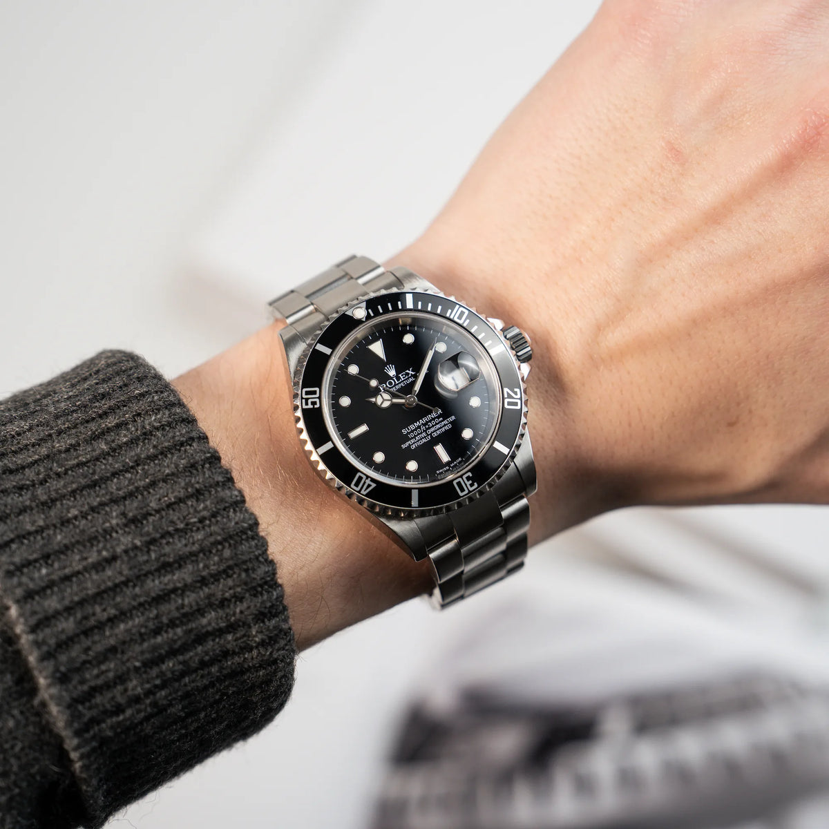 Mann trägt die Rolex Submariner Date in Schwarz mit der Referenz 16610T an seinem Handgelenk