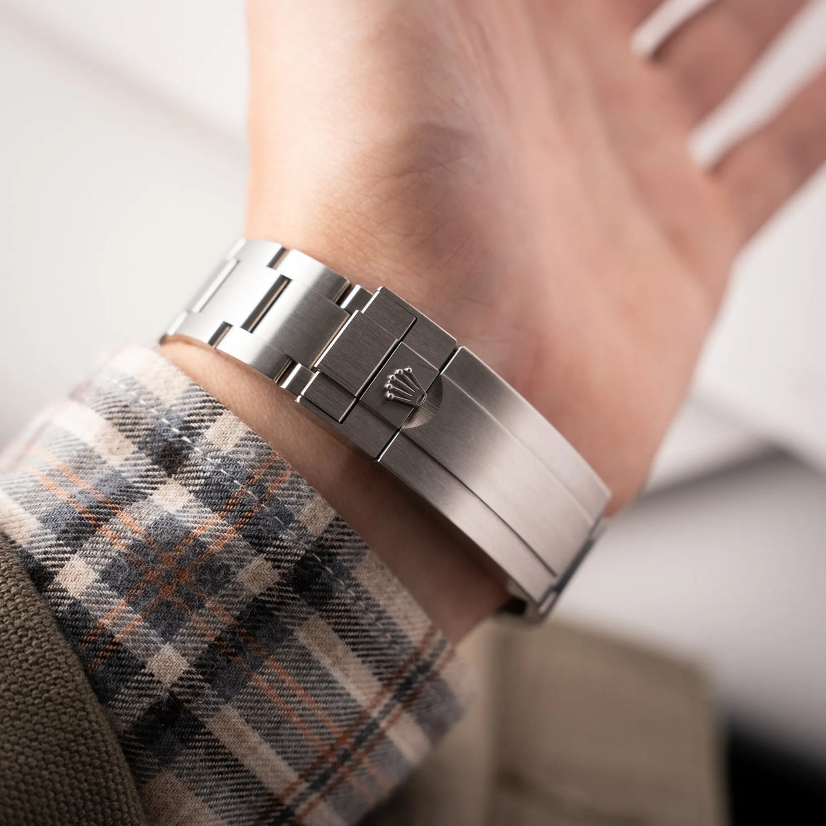 Mann präsentiert das Armband und die Schliesse der Rolex Submariner Date Starbucks der Referenz 126610LV mit der grünen MK2-Lünette