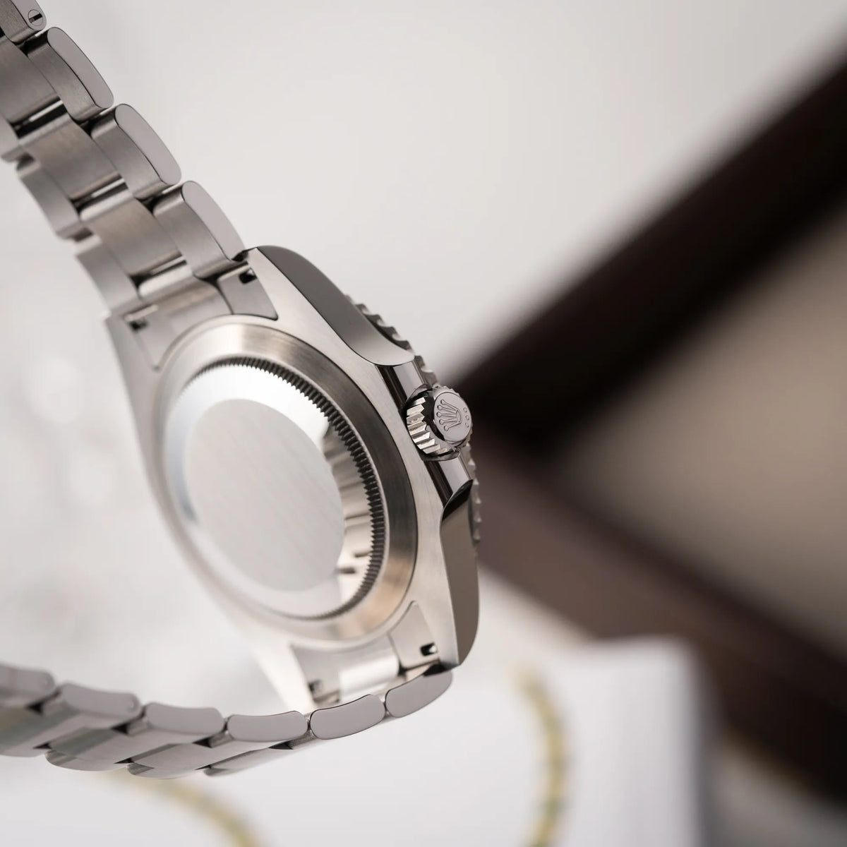 Produktfotografie der Rolex Submariner Date Starbucks der Referenz 126610LV mit der grünen MK2-Lünette zeigt den Gehäuseboden und die Aufzugskrone