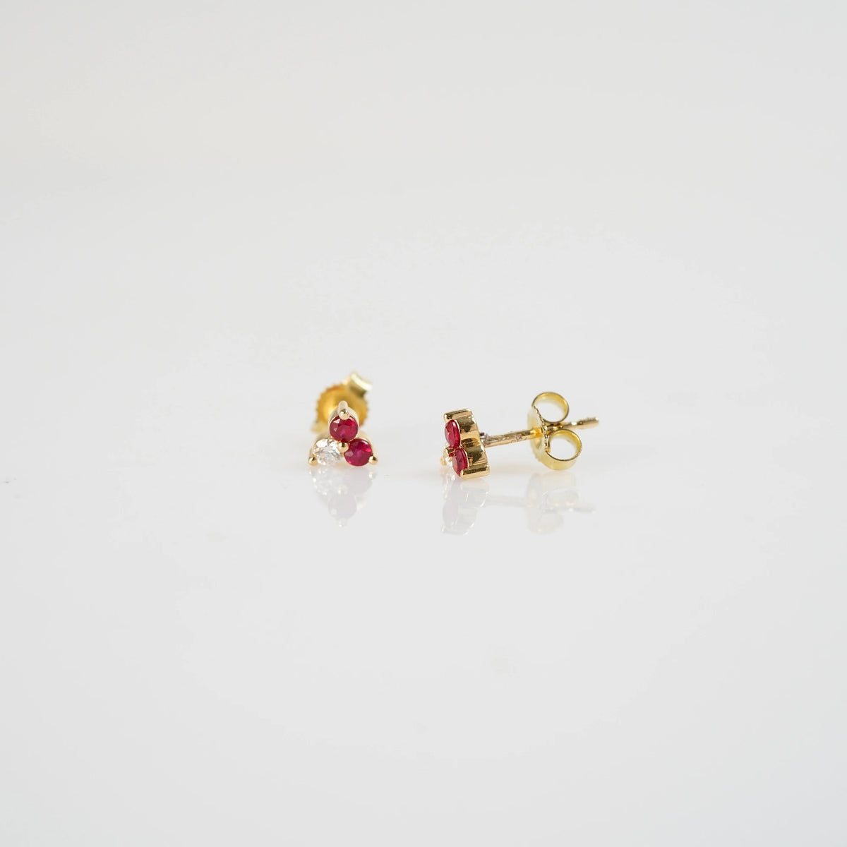Produktfoto der gelbgoldenen Rubin Ohrstecker aus der Schmuckatelier Lang Collection mit zwei Rubinen und einem Brillanten - der linke Ohrstecker zeigt dabei die frontale Ansicht, der rechte Ohrstecker  die seitliche Ansicht