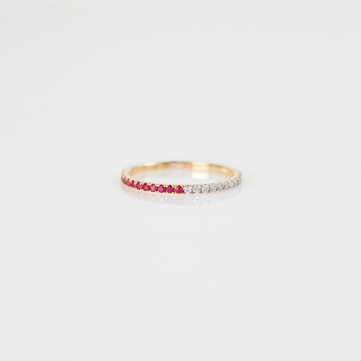 Produktfoto des liegenden Memoire Rings aus der Schmuckatelier Lang Collection, der halb mit Rubinen und halb mit Diamanten besetzt ist