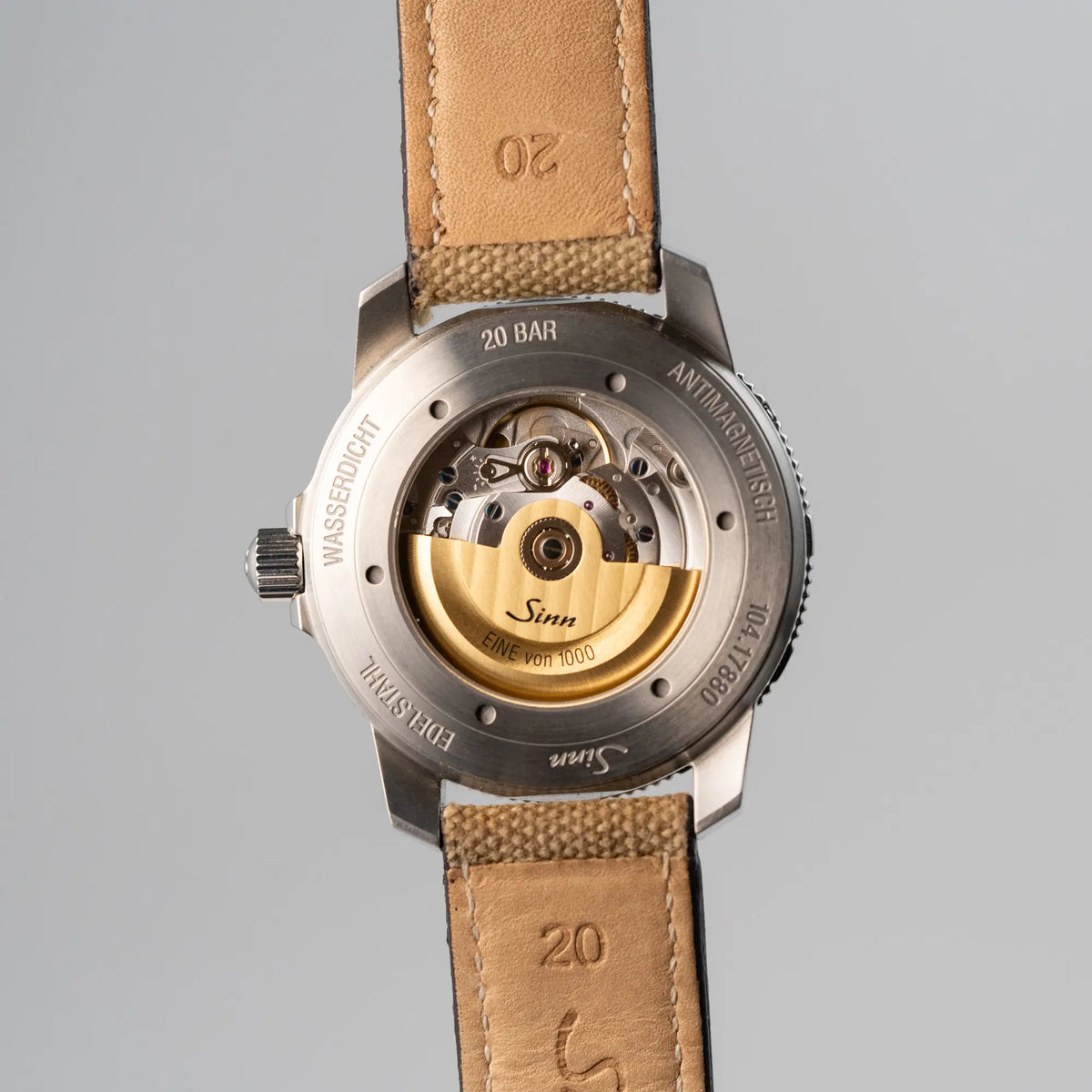 Produktfotografie der Taucheruhr Sinn Automatik SA in Blau mit beigen Akzenten am Textilband mit Fokus auf dem gläsernen Gehäuseboden