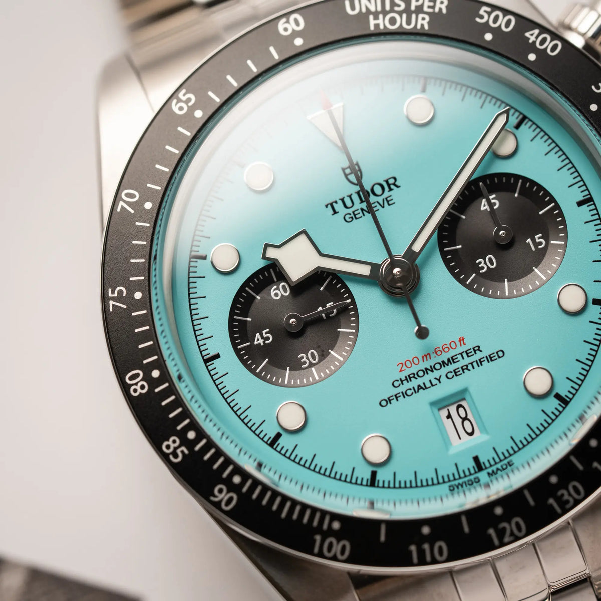 Nahaufnahme des Tudor Black Bay Chronograph Flamingo mit dem türkis-blauen Zifferblatt mit schwarzen Totalisatoren und schwarzer Lünette mit Zähler-Skala zeigt die Struktur des Zifferblatts und den Snow-Flake-Zeiger