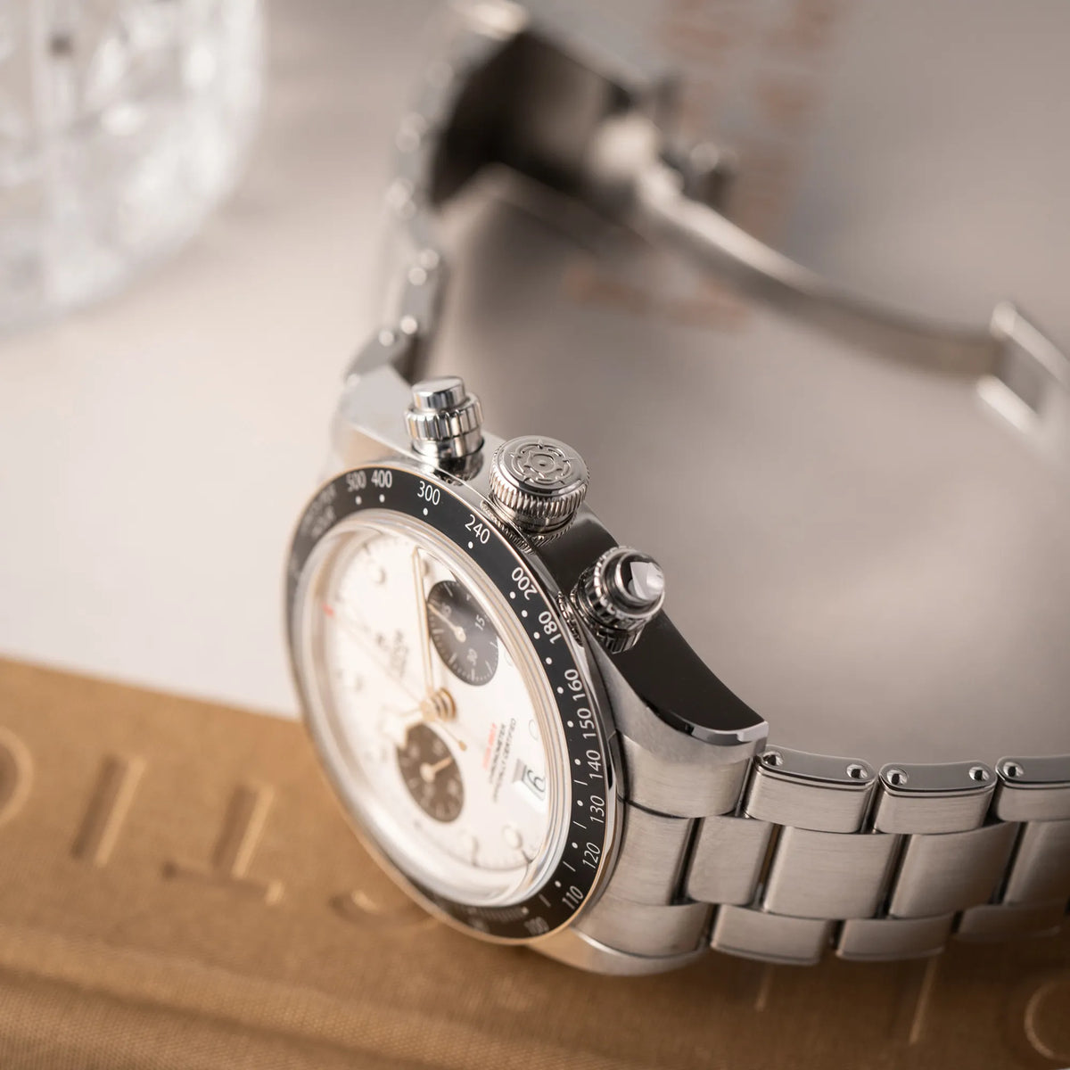 Produktfotografie von dem Tudor Black Bay Chronograph 79360N mit dem Panda-Zifferblatt in weiß mit schwarzen Totalisatoren zeigt die seitliche Gehäuseflanke mit Blick auf die Aufzugskrone und die Chronograph-Drücker