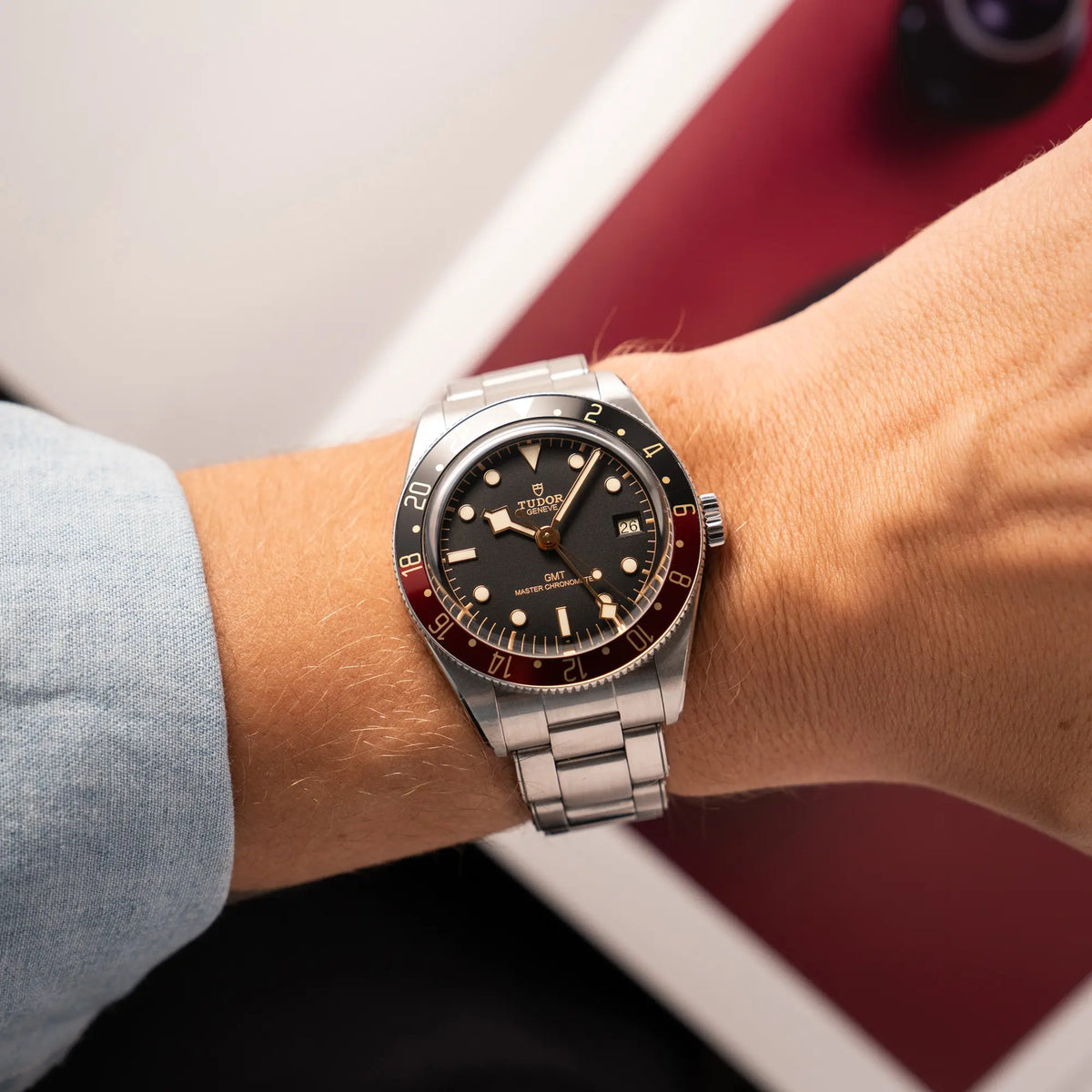 Mann trägt die Tudor BlackBay GMT Coke der Referenz 7939G1A0NRU mit der schwarz-roten Lünette und bronzefarbenen Details am Edelstahlarmband  für einen Wristshot an seinem Handgelenk