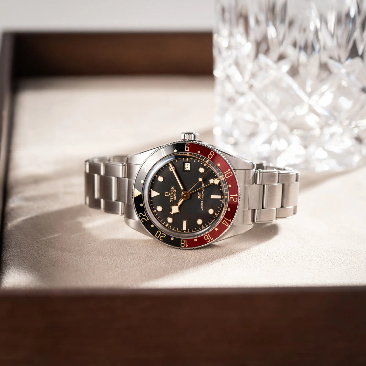 Tudor BlackBay GMT Coke der Referenz 7939G1A0NRU mit der schwarz-roten Lünette und bronzefarbenen Details am Edelstahlarmband  liegt auf einem Juwelierstablet